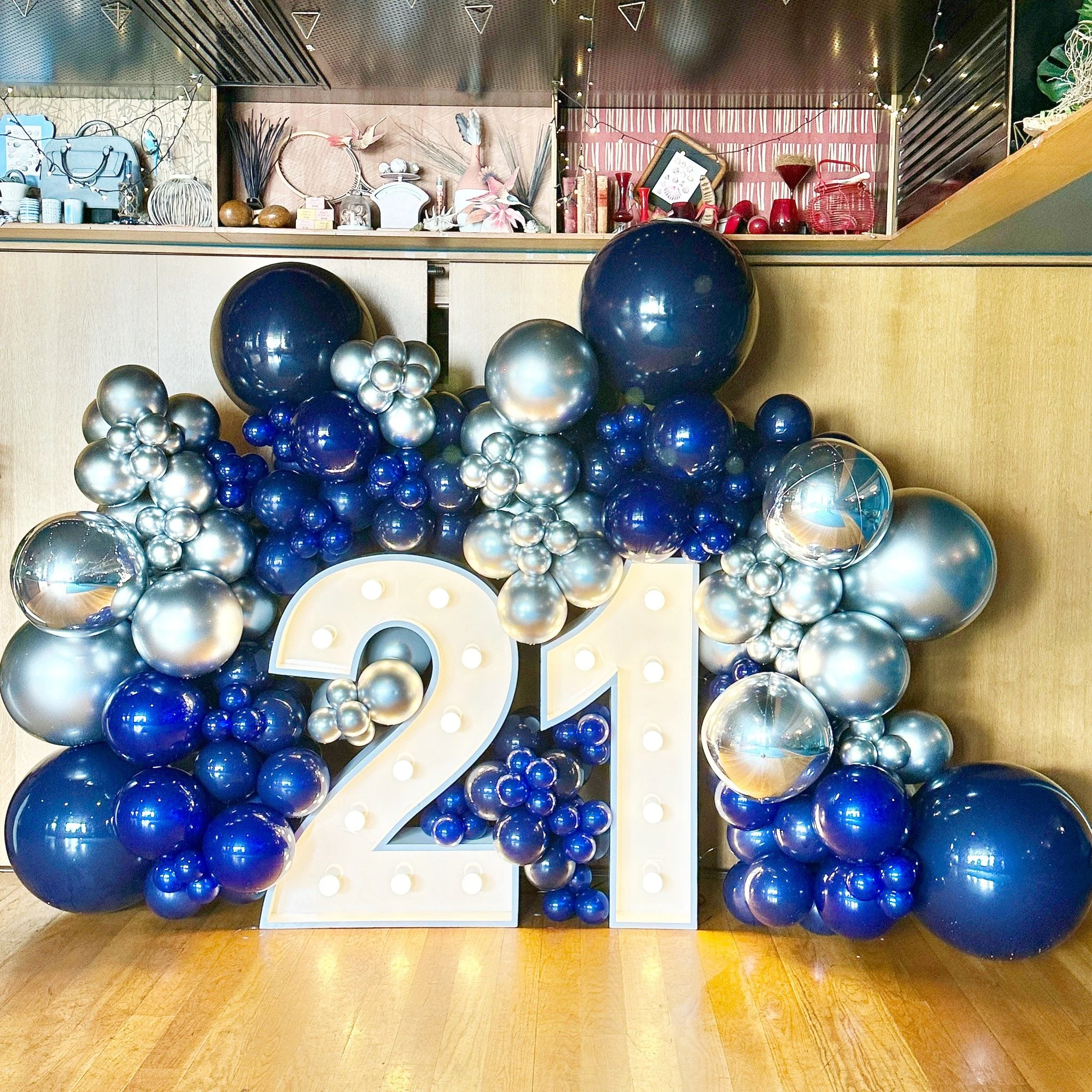 Decorative balloon arrangement with a large illuminated number 21 i