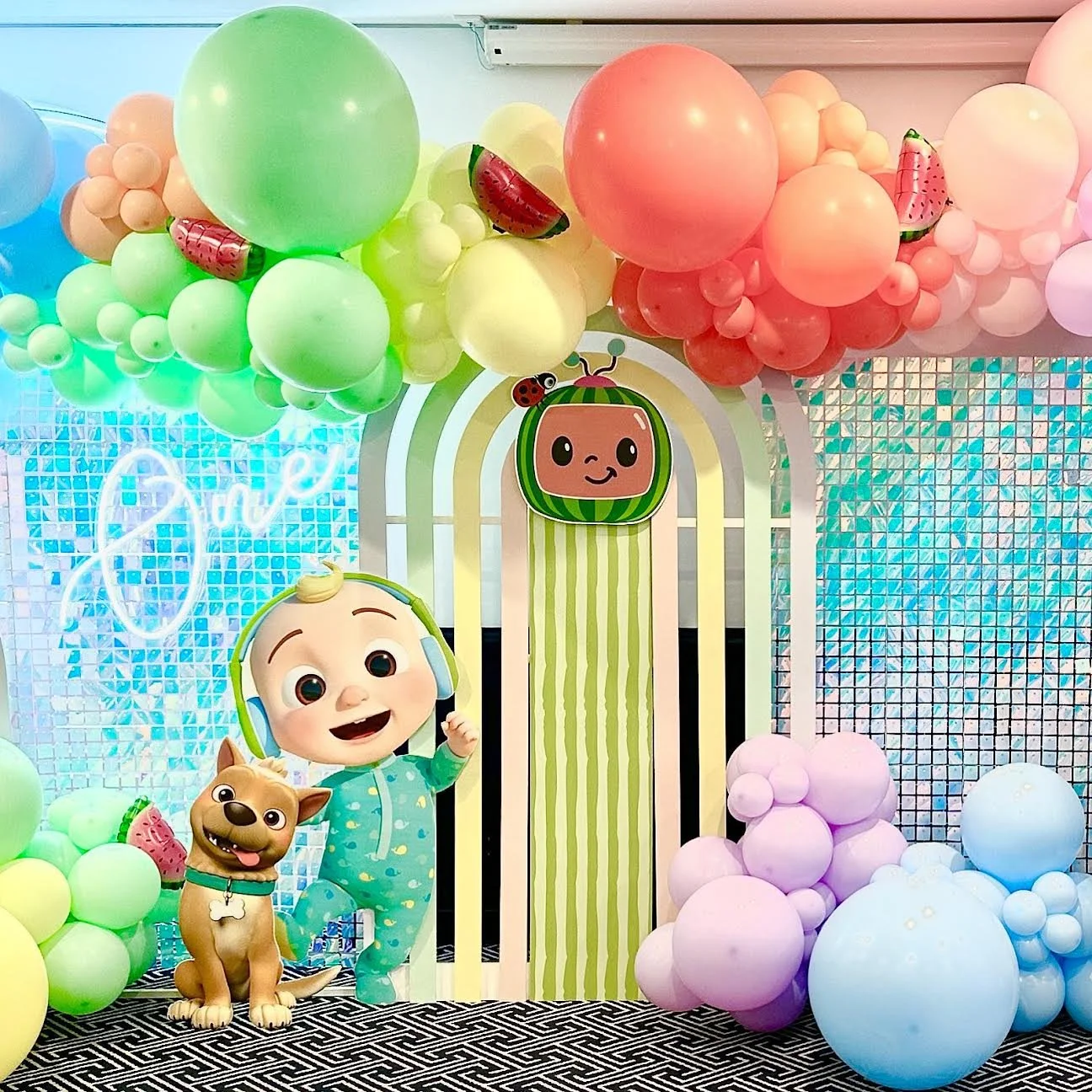 Cocomelon birthday set up with balloons, props and a pastel arch backdrop