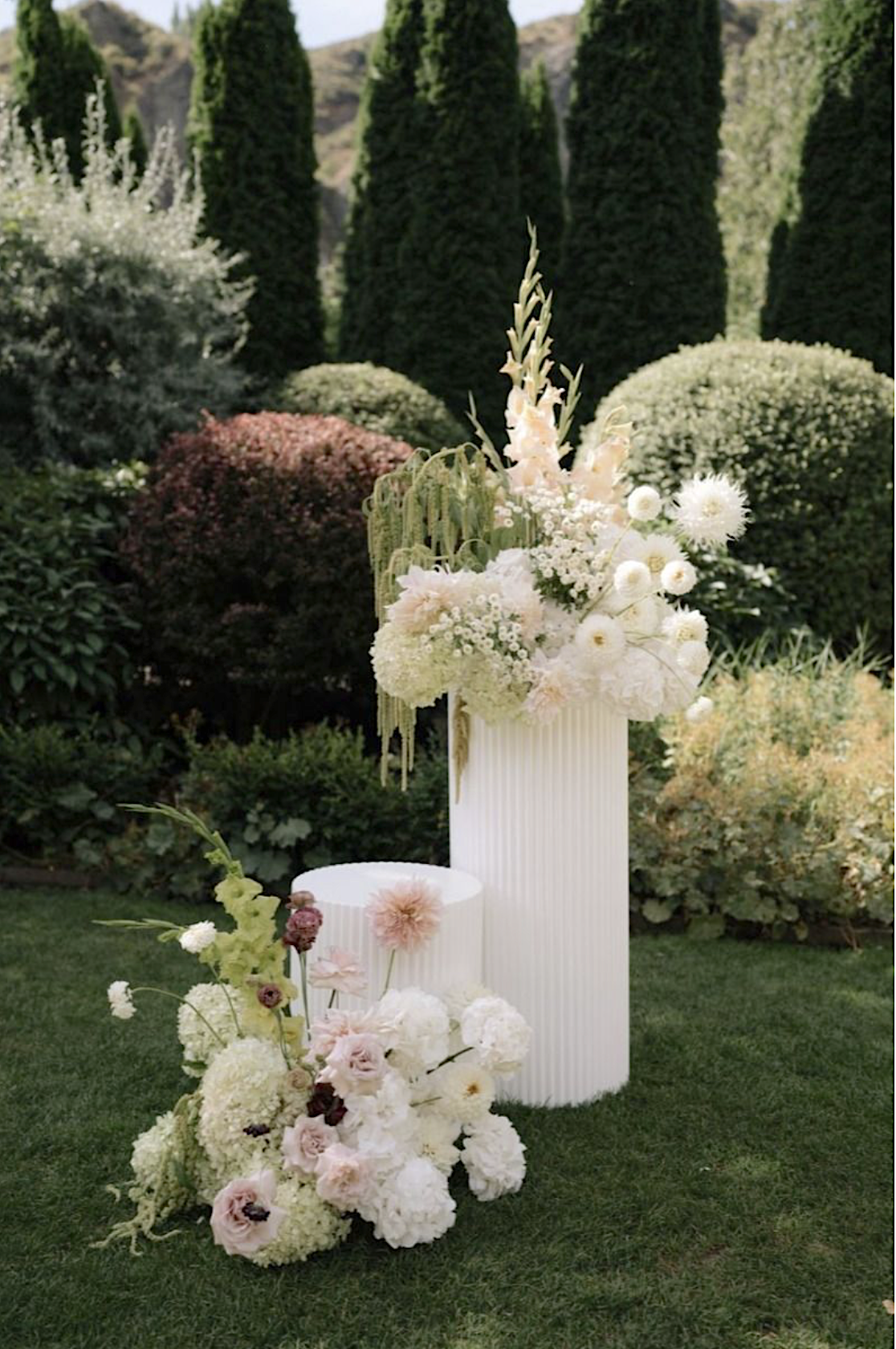 White ripple round cake plinths with faux floral hire