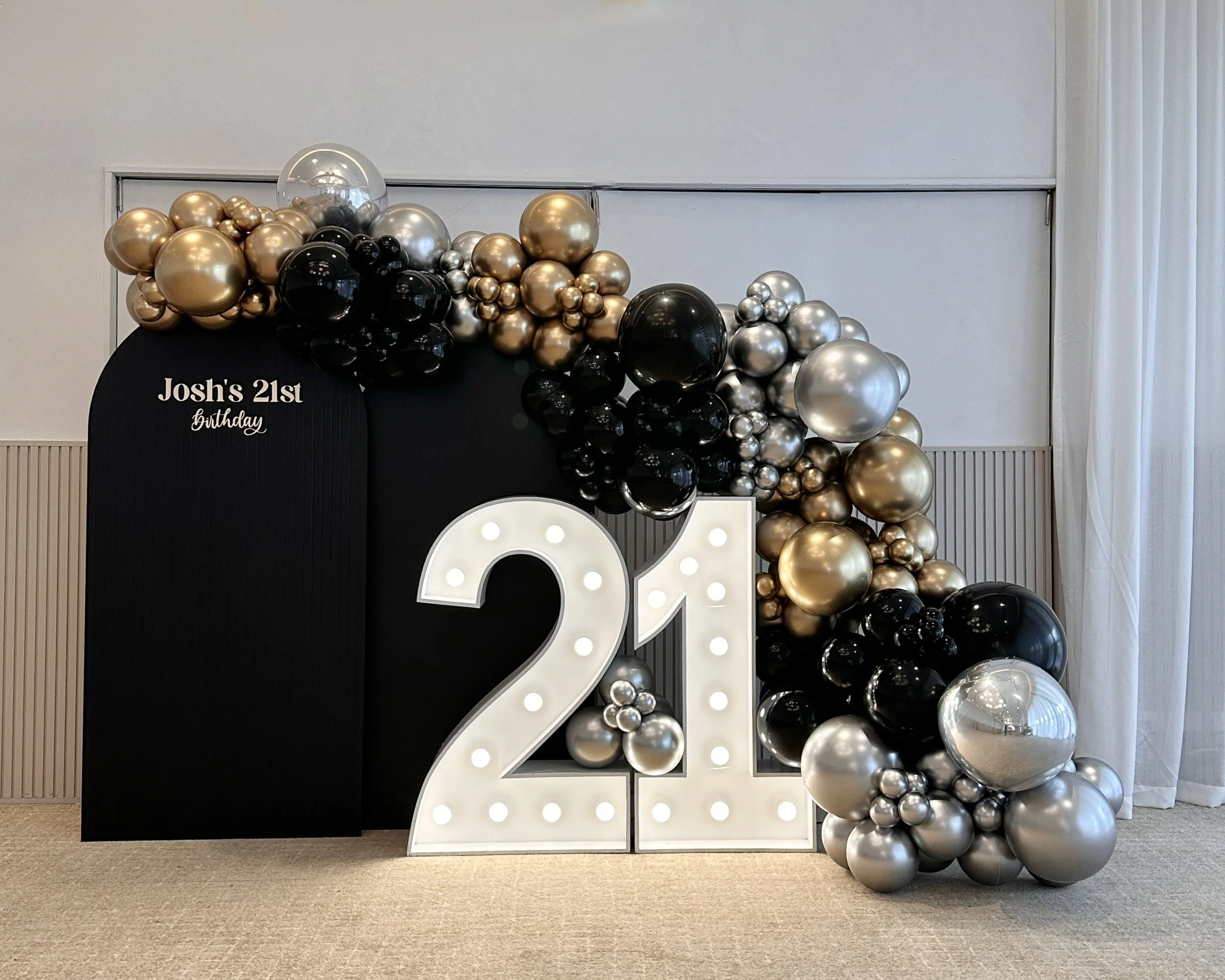 21st Birthday backdrop with black arch, balloons and light up number 21