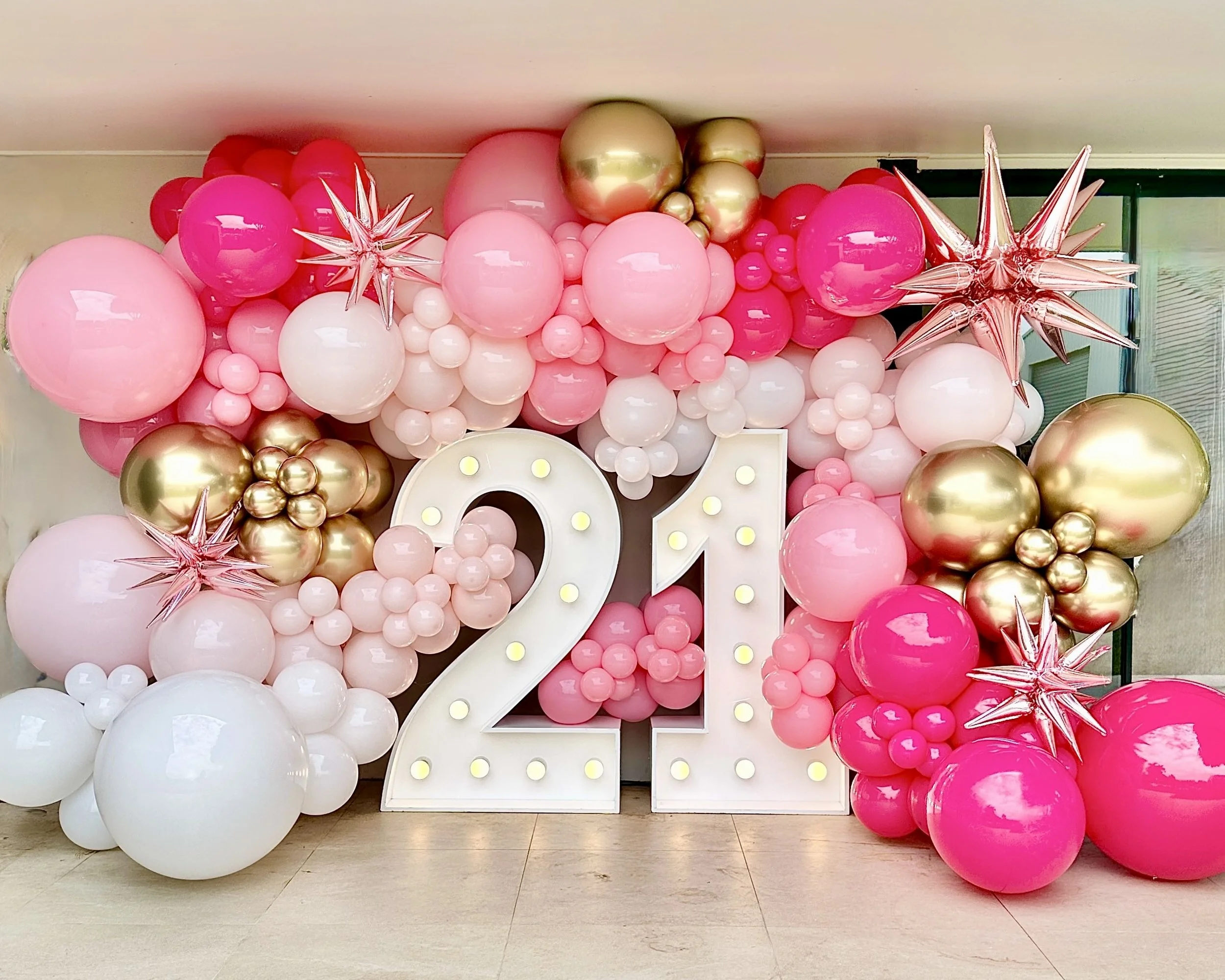 Balloon wall surrounding large illuminated white number 21 for a Twenty First birthday party