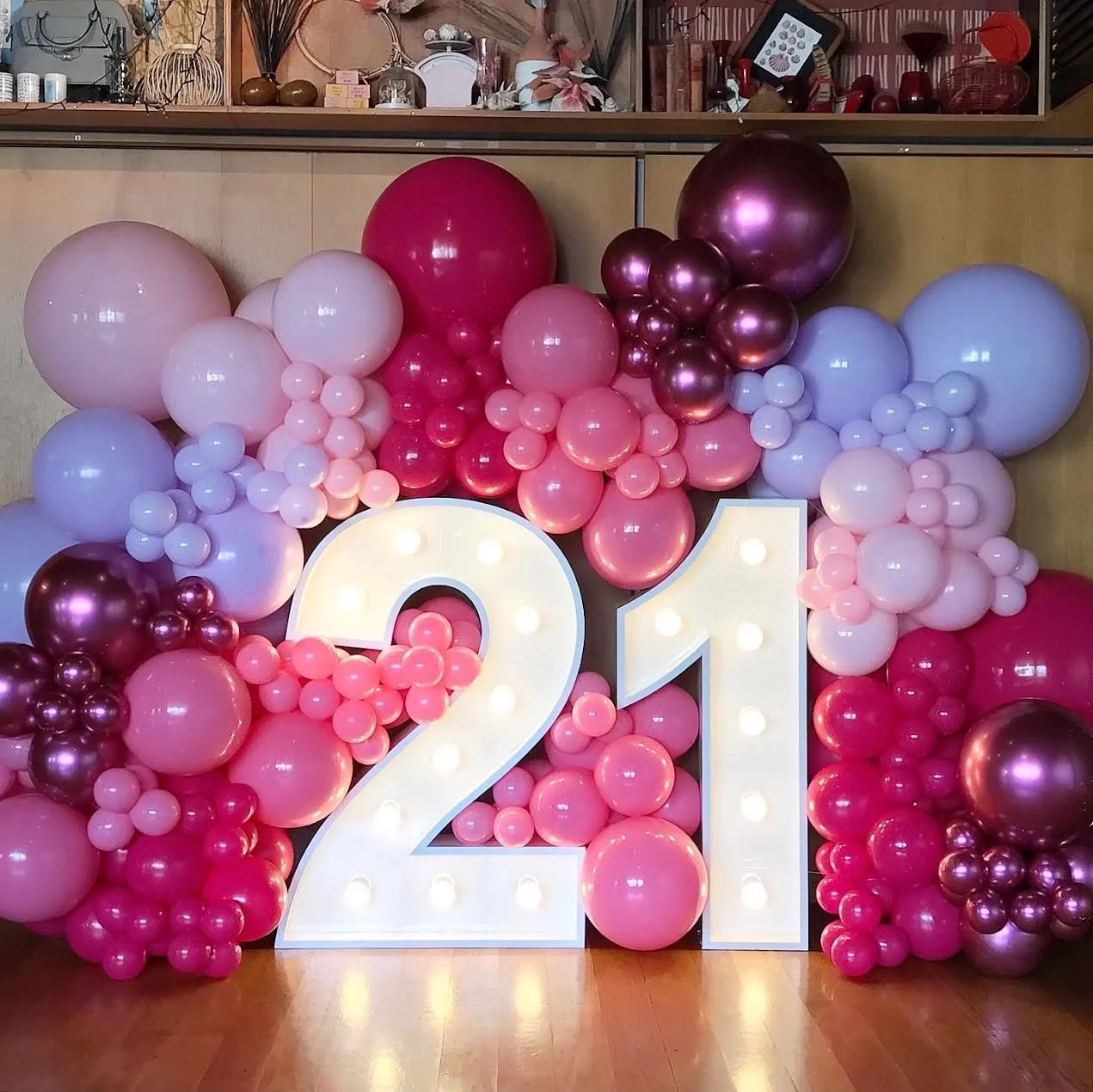 Balloon wall surrounding large illuminated white number 21 for a Twenty First birthday party