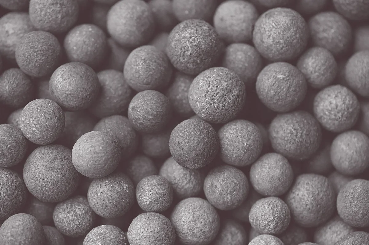 Close-up of numerous small, round, gray metallic balls with textured surfaces.