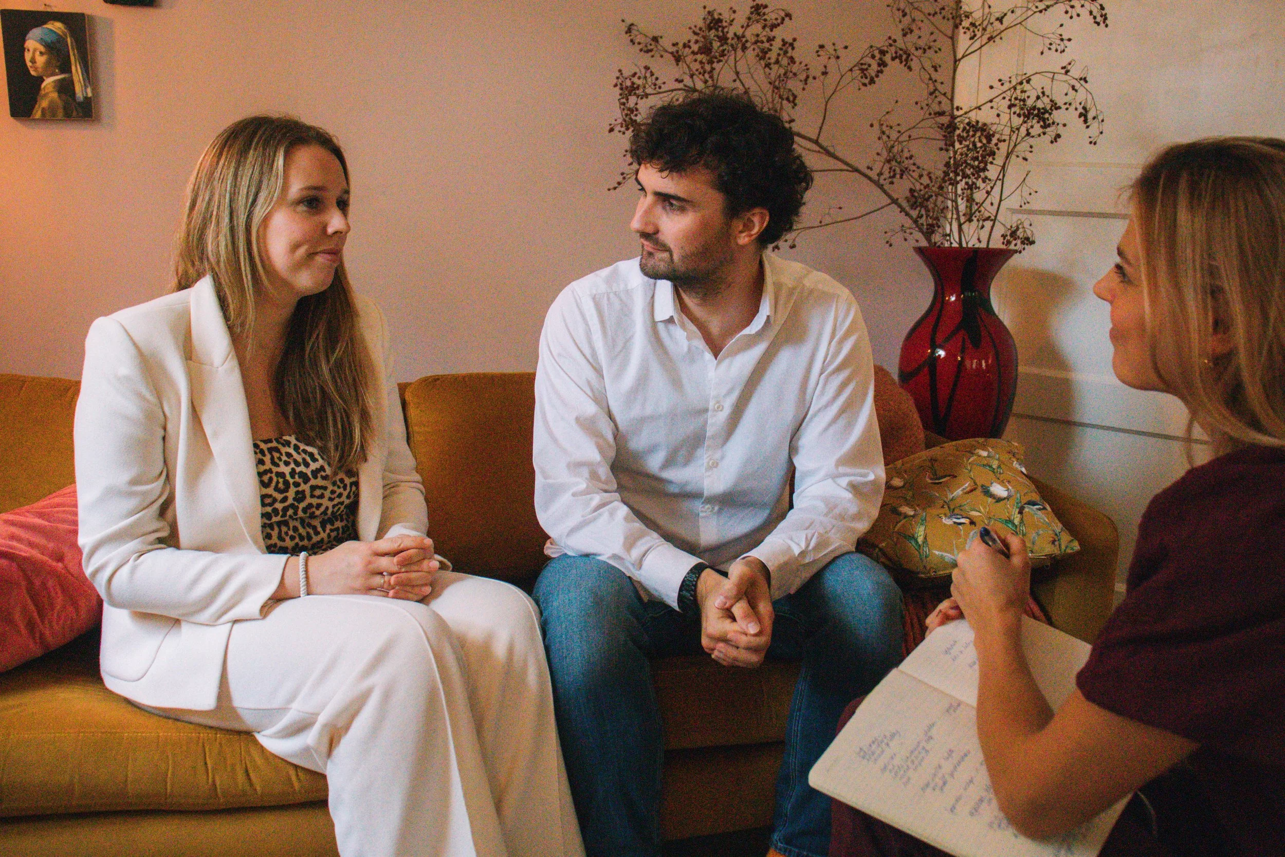 Drie mensen in gesprek. Een koppel op de bank en Gabie de relatiecoach van GAAN relatiecoaching er tegenover. Een huiskamer setting in een ontspannen sfeer werken aan het verbeteren van je relatie