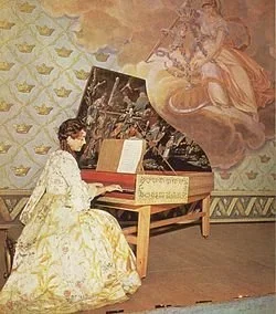 Kvinna i 1700-tals klädsel spelar piano i ett rum med väggmålningar.