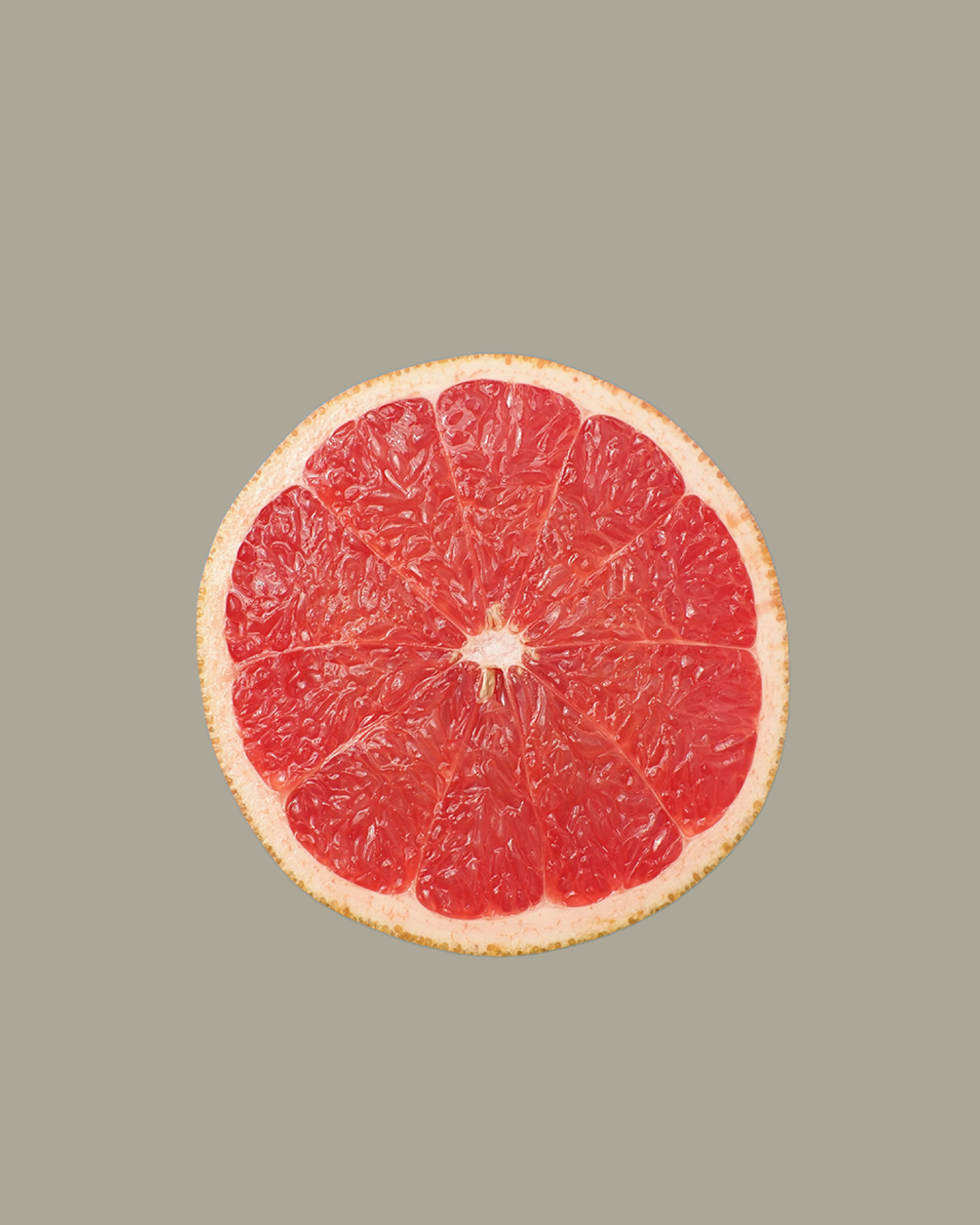 Une tranche de pamplemousse rouge vif sur fond gris clair.