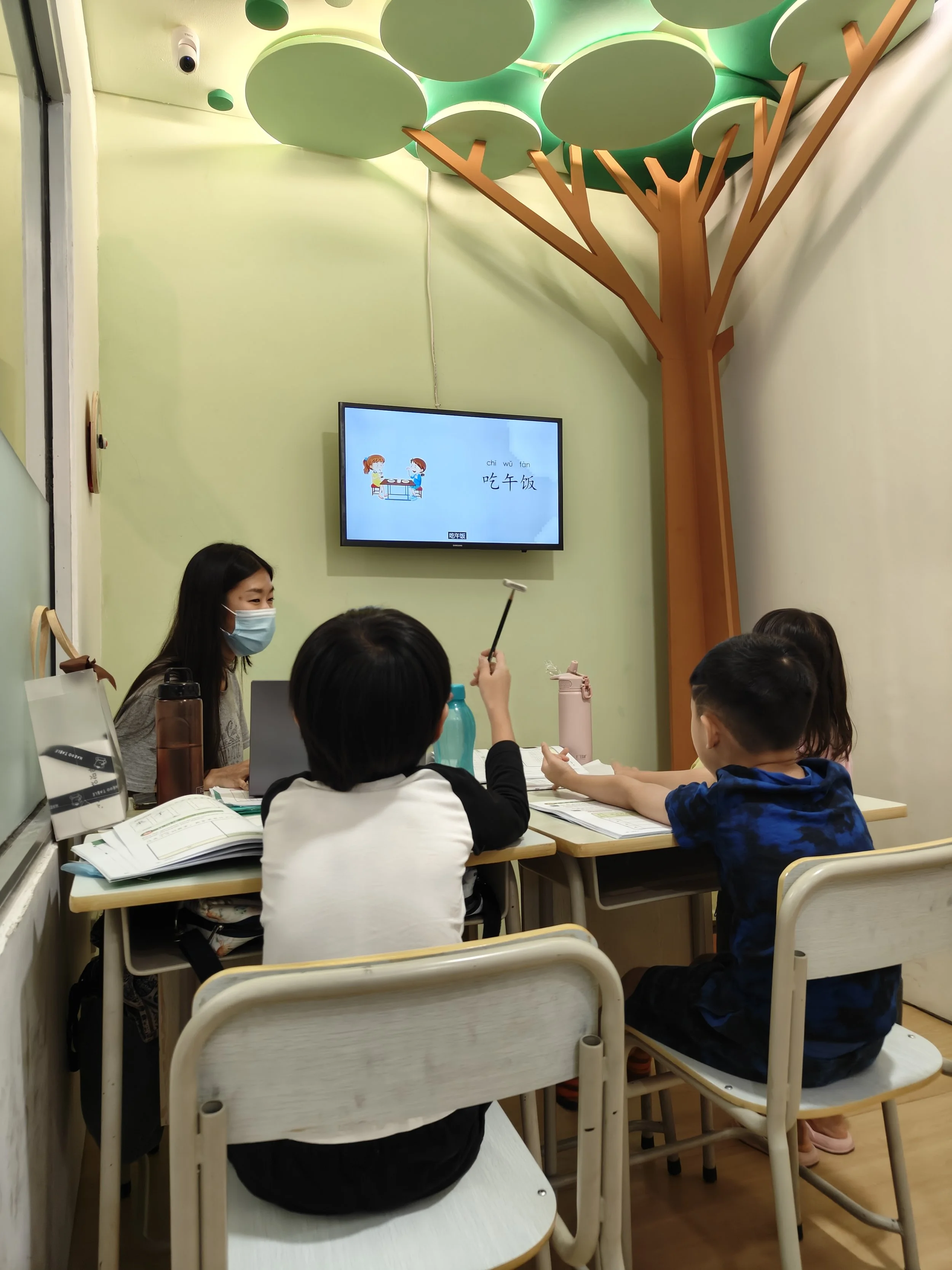 children classroom with the teacher teaching through interactive media