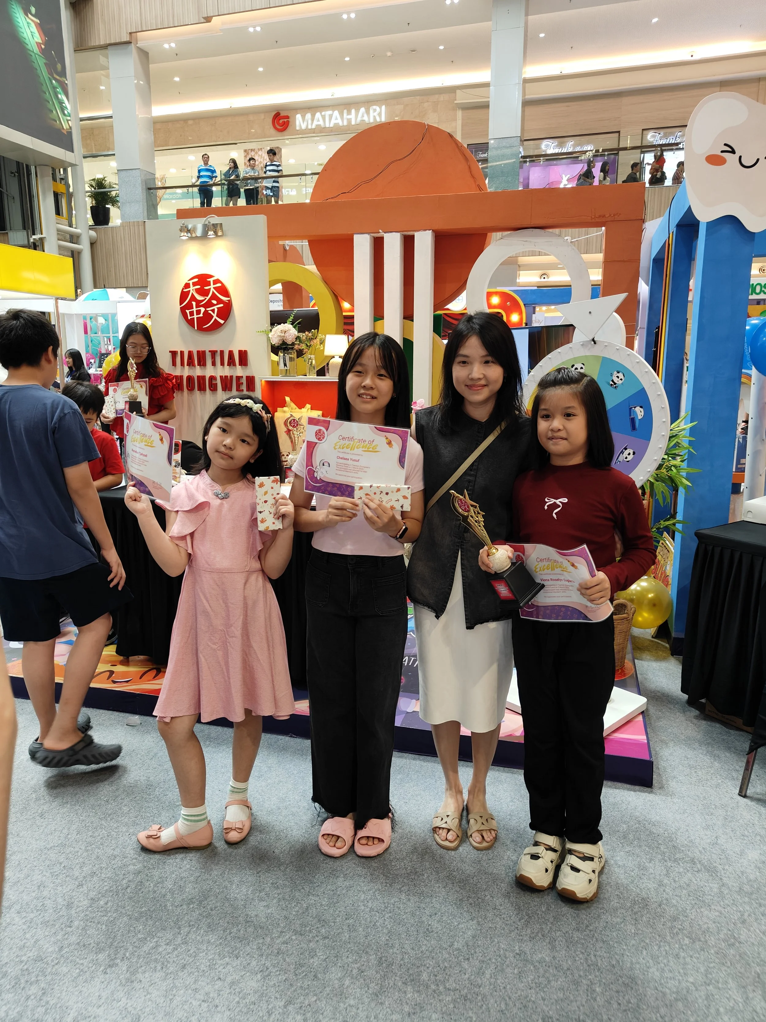 students and their teacher posing after a madarin competition