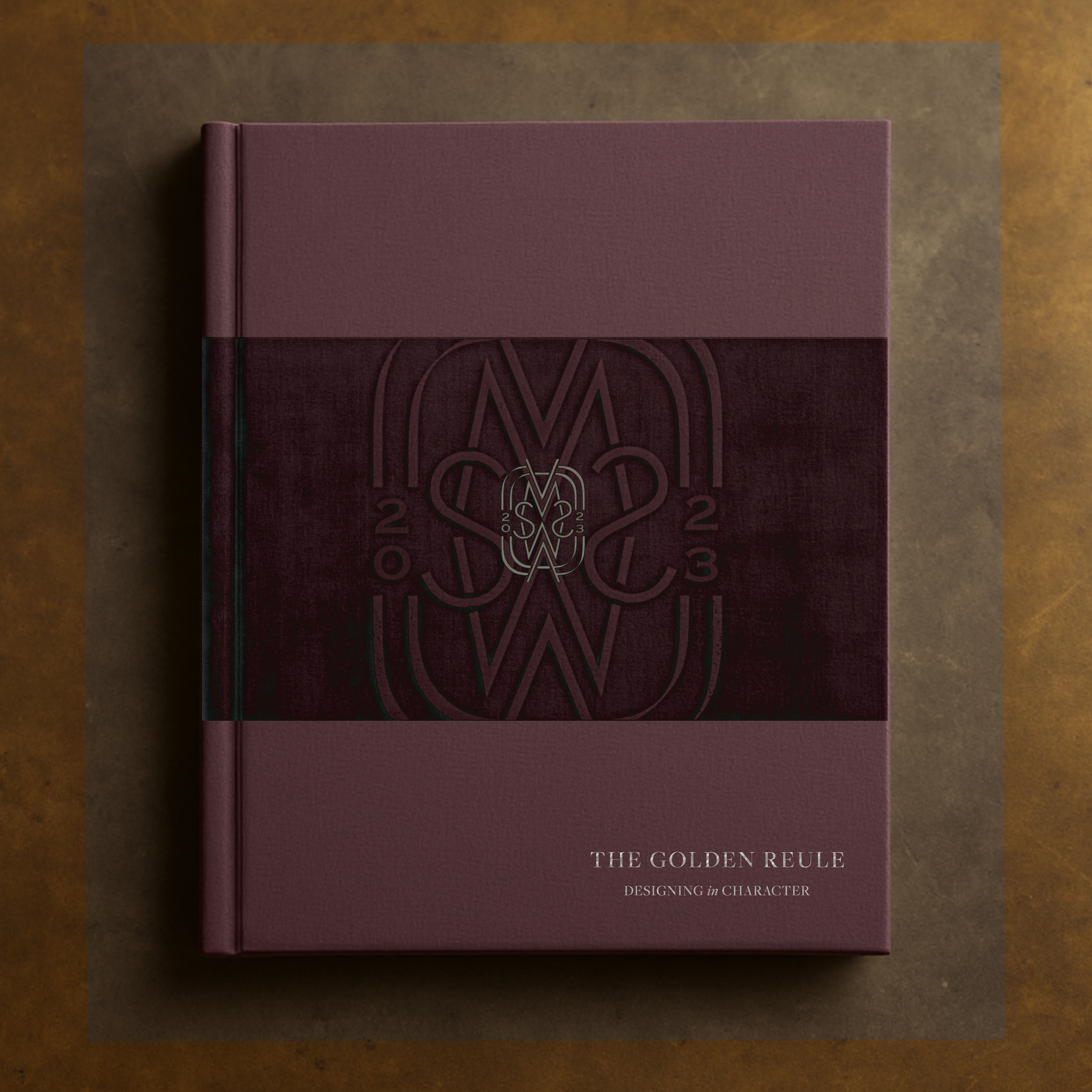 A close-up of a purple book titled 'The Golden Rule: Designing in Character' on a brown surface.