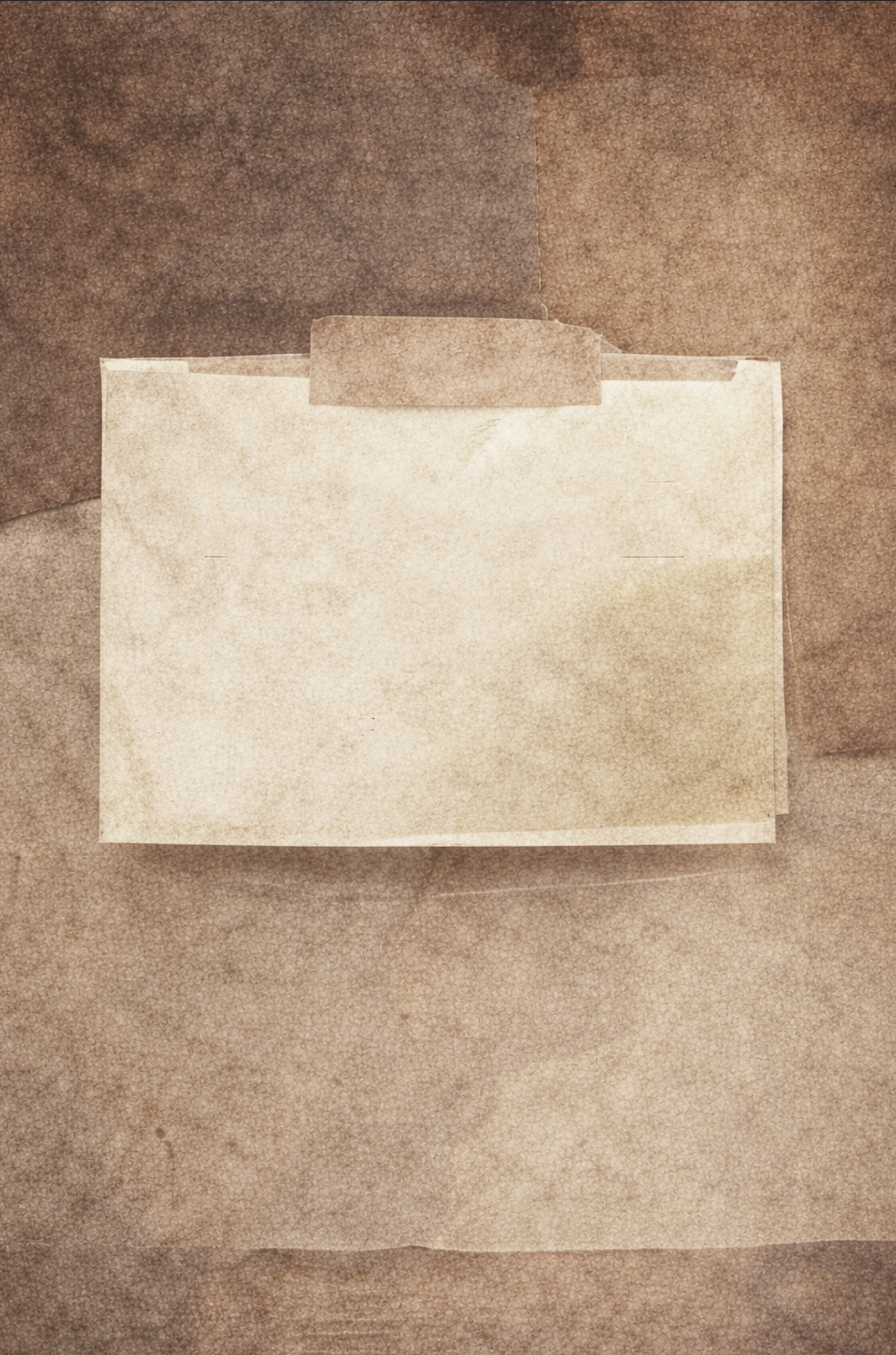 A sheet of blank paper taped to a brown paper surface with a piece of brown masking tape.