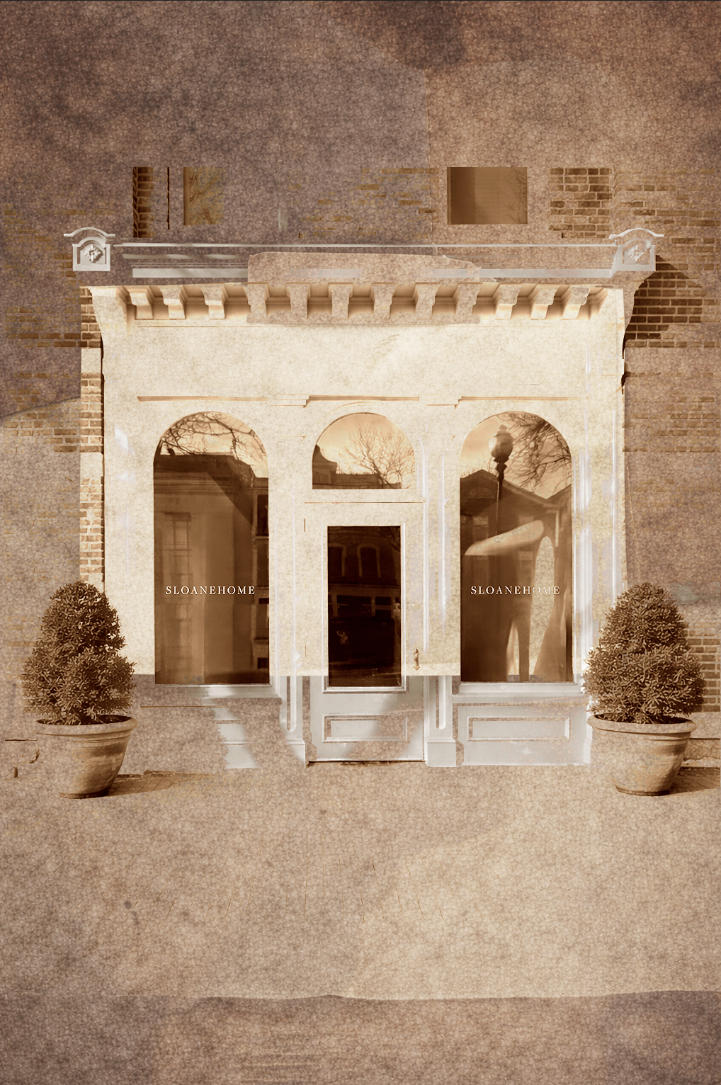 Storefront with window decals reading "SLOANE HOME," two potted topiary plants, and a brick building behind.