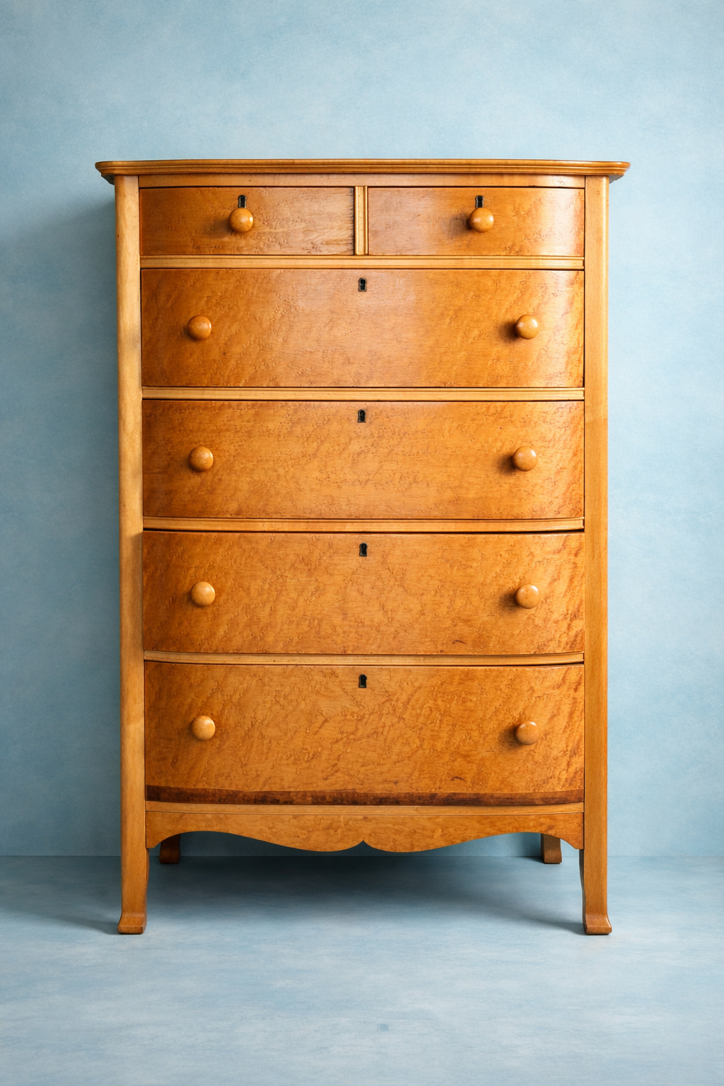 A wooden vintage dresser with five drawers and round knobs against a light blue background.