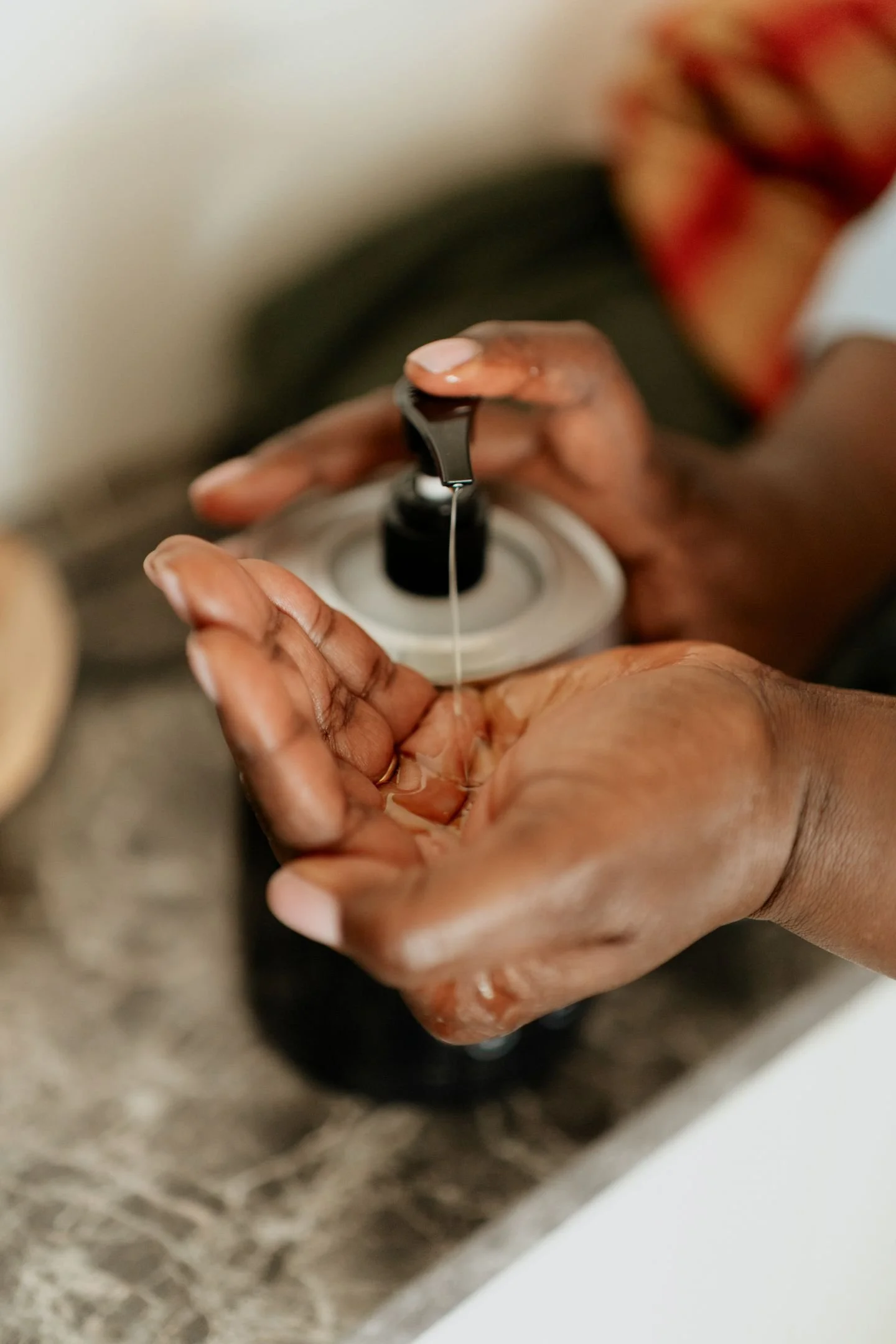 Une personne tient une boîte d'huile, avec une goutte de liquide suspendue à la boîte.