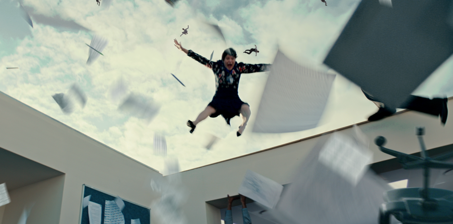 A woman falling through the sky with papers and small figures around her, as seen from below in an office environment.