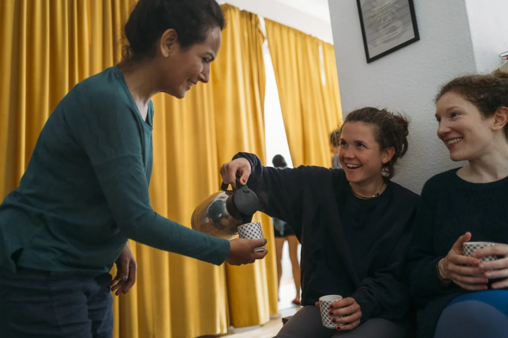 Onda members sharing tea and laughing together at Onda Yoga Studio Berlin