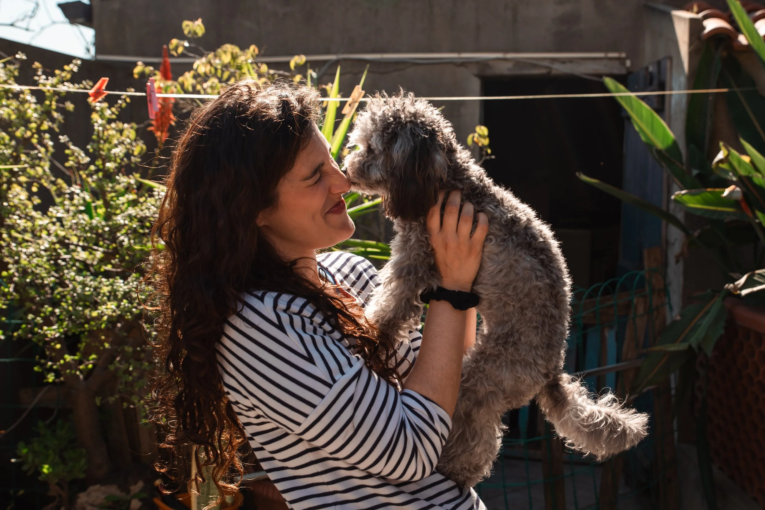 Donna che tiene in braccio un cucciolo di cane all'aperto