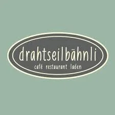 Logo des Cafés "Drahtseilbähnli" mit ovalem Design und schwarzem Hintergrund auf grünem Hintergrund
