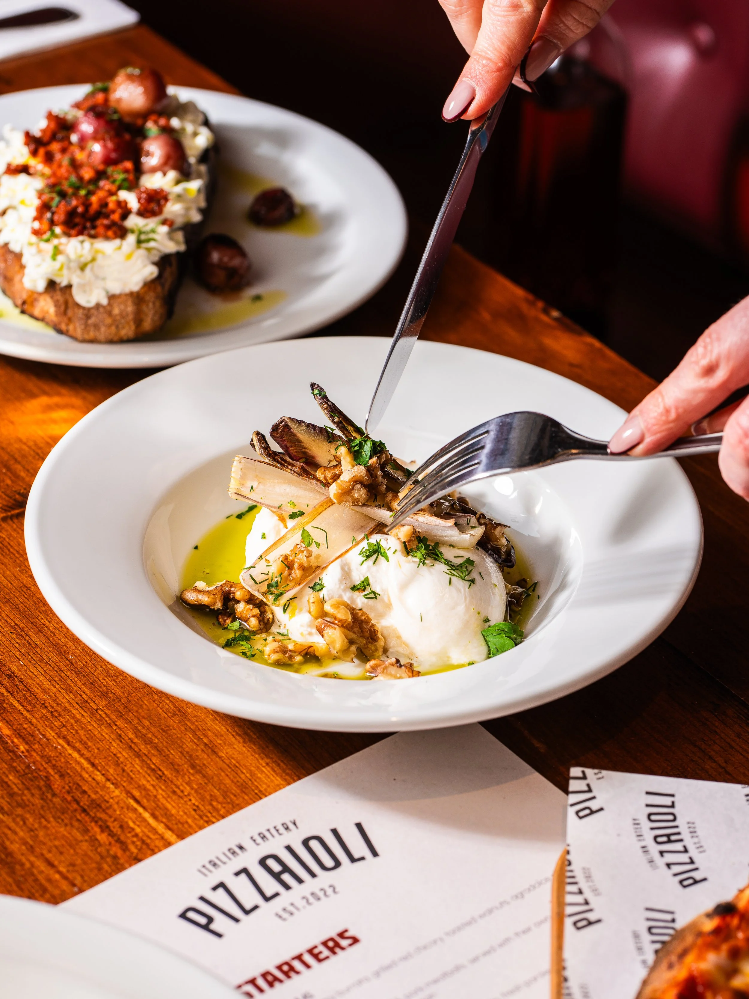 A person cuts into some burrata served at Pizzaioli Ayr.
