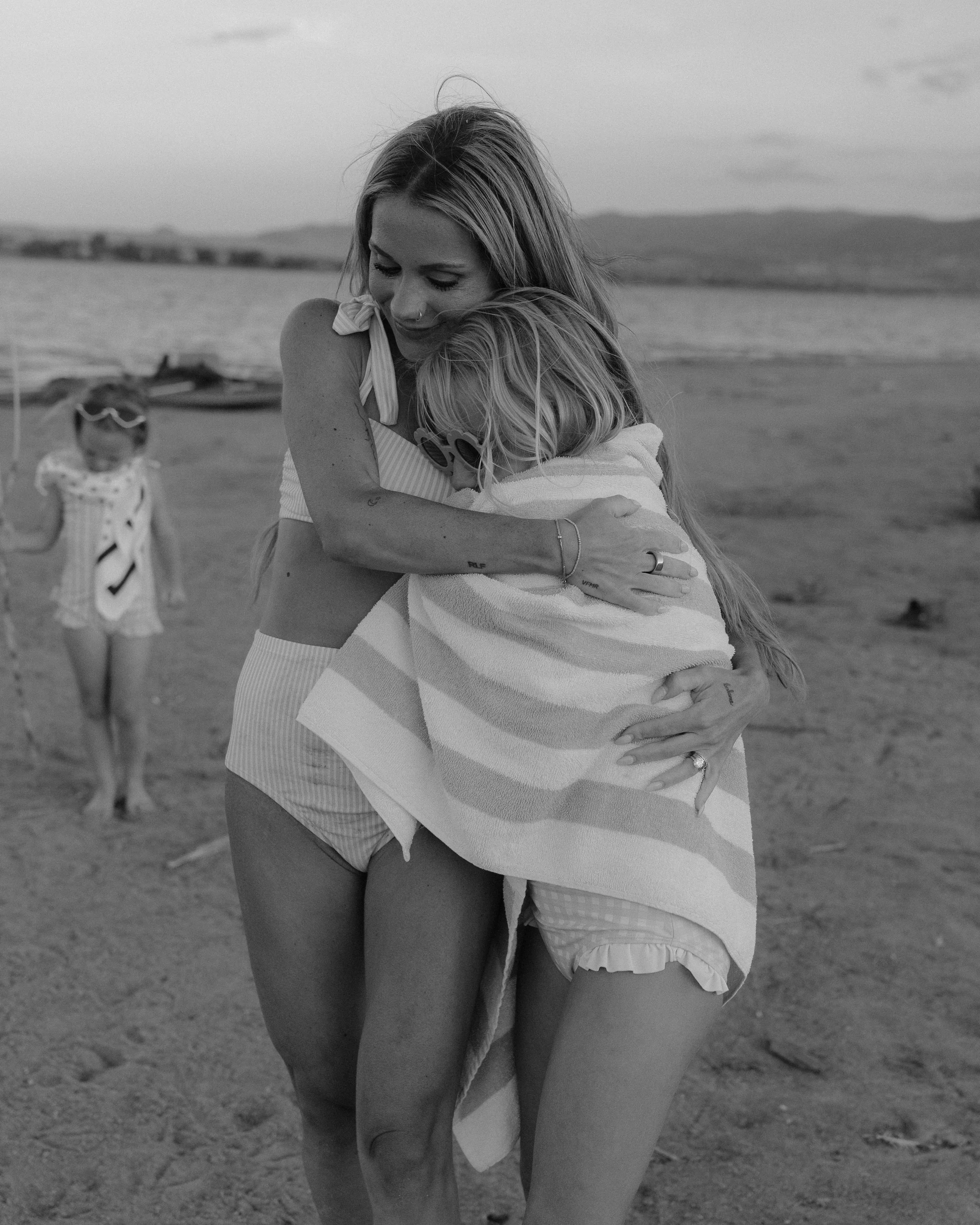 Mother hugs child at the beach