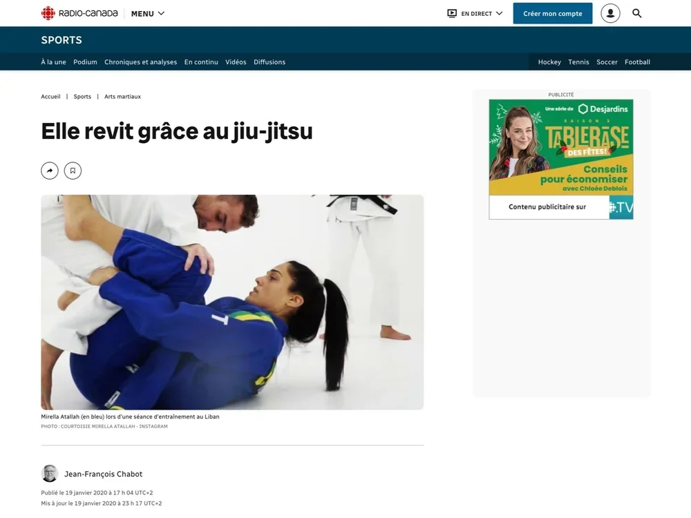 A woman in a blue judo gi practicing ground techniques with a man in a white gi in a martial arts training session.