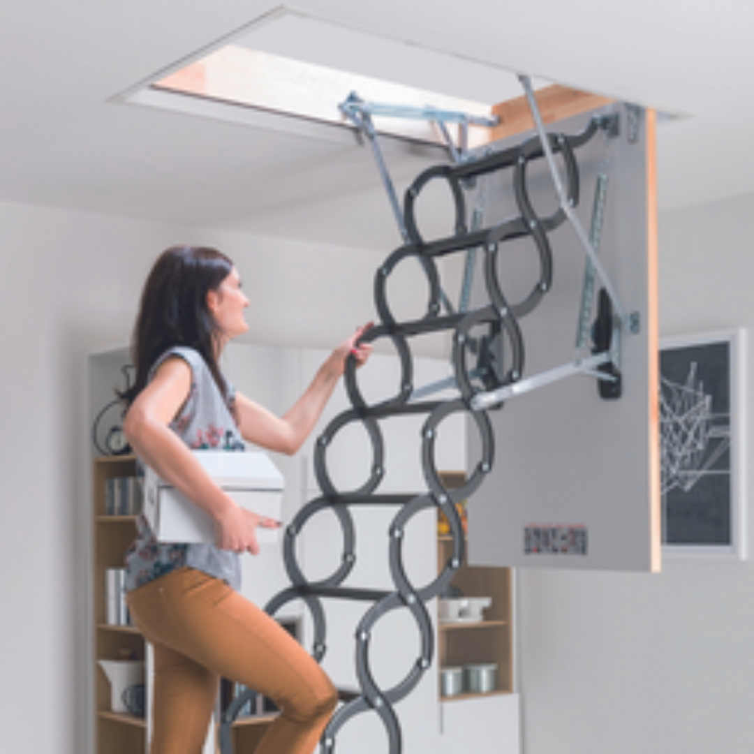 A woman opening a ceiling hatch with a ladder, holding a white box, in a room with bookshelves and a basketball hoop picture on the wall.