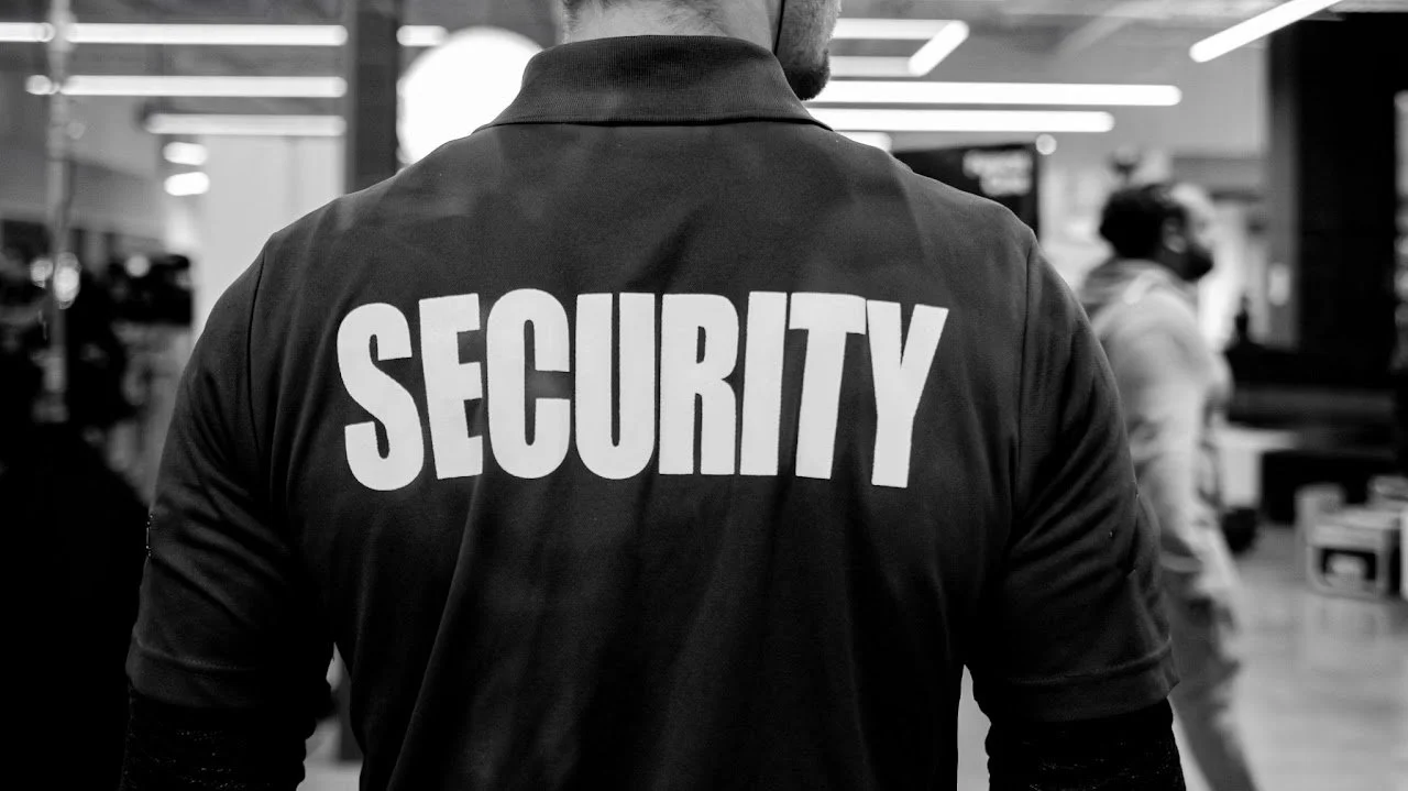 Mann trägt eine Sicherheitsweste in einer öffentlichen Halle.