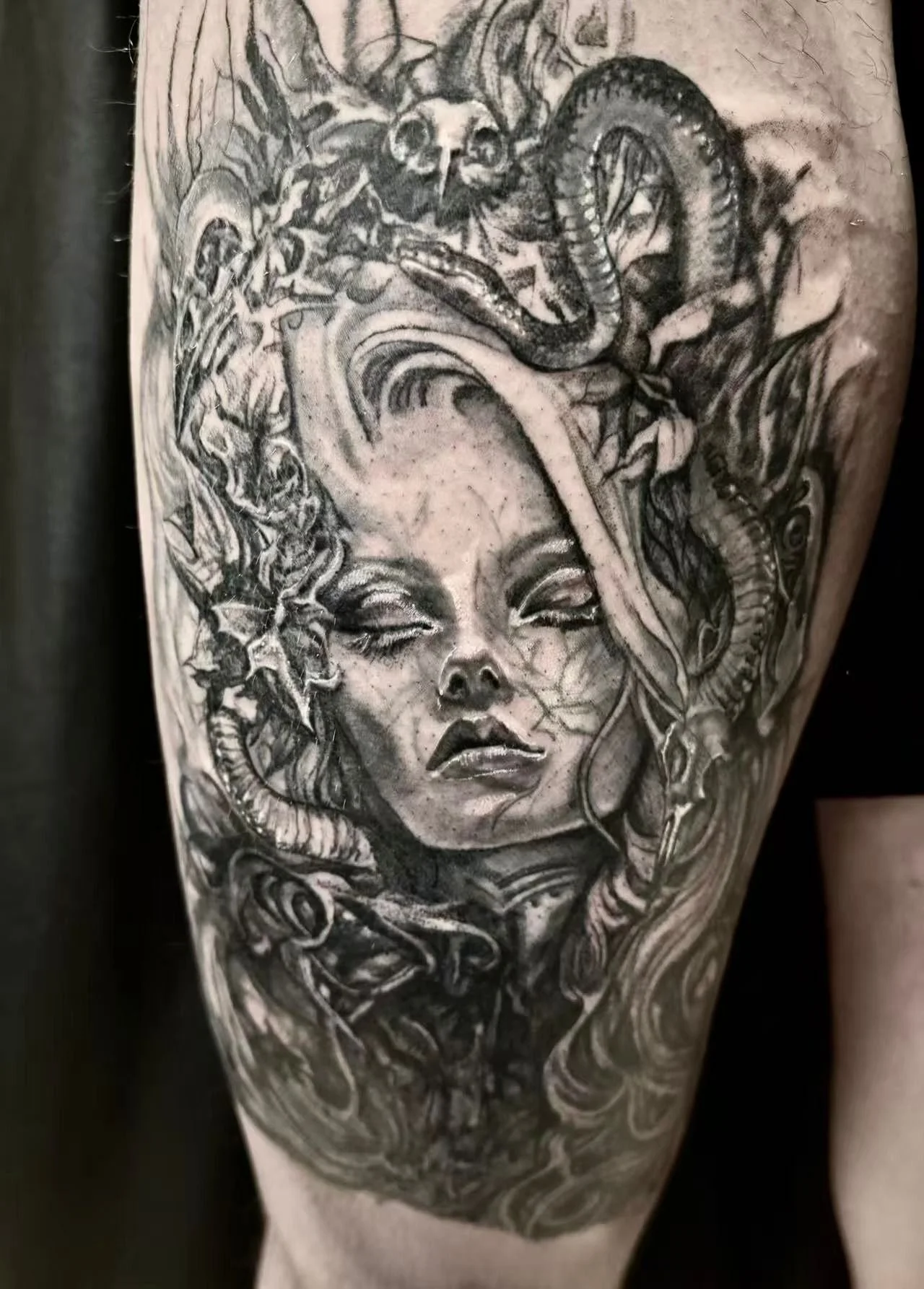 Black and grey realism Medusa tattoo on thigh — serpents, bird skull, and floral detail by Siren Tattoo, Lucerne