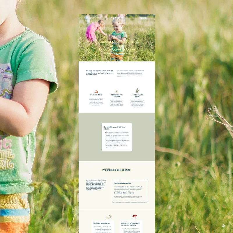 A website displayed on a vertical screen in a grassy outdoor setting with children playing.