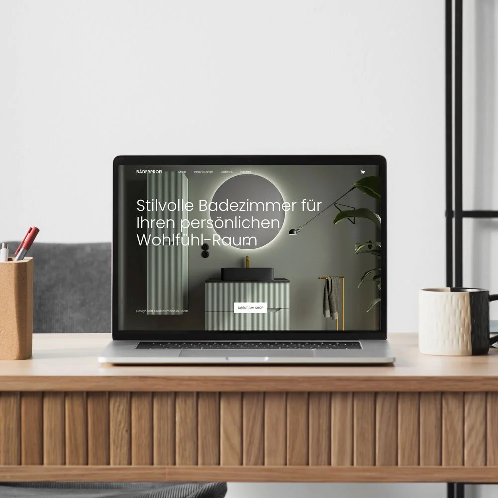 Ein Laptop auf einem Holzschreibtisch, der eine Webseite für Badezimmereinrichtungen anzeigt, mit einem weißen Wandhintergrund.