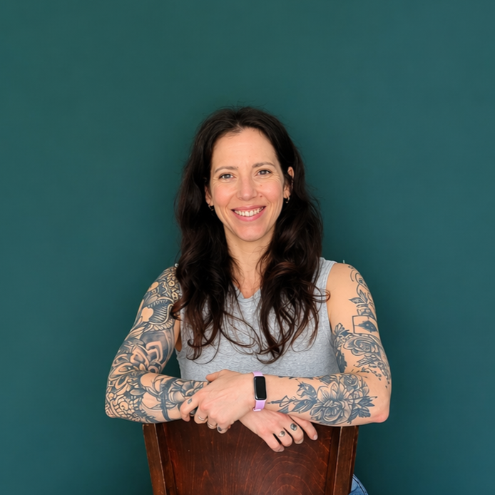 Headshot of smiling female tutor with short blonde hair wearing a lanyard.