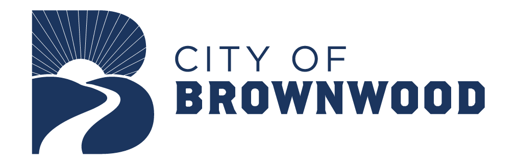 Logo of the City of Brownwood with a stylized road and sunrise scenery