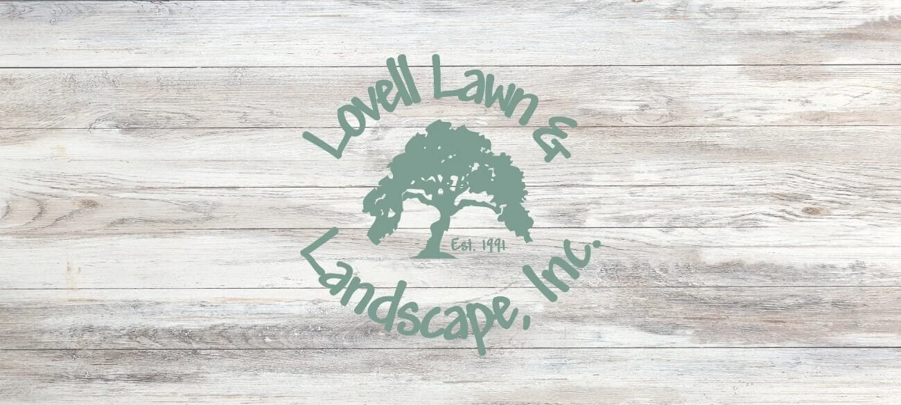 Logo of Lowell Lawn & Landscape, Inc. with a tree graphic, on light wooden background.