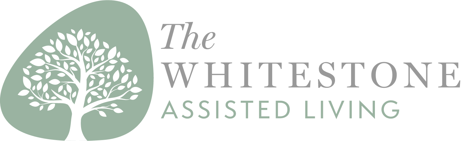 Logo for The Whitestone Assisted Living featuring a white tree with many branches and leaves inside a pale green shape, with the text 'The Whitestone Assisted Living' next to it.