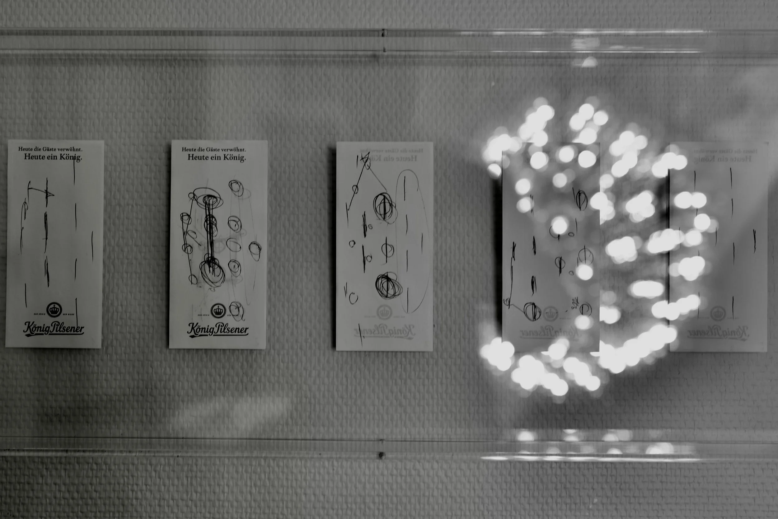 Schwarz-weiß-Foto von vier Karten mit handschriftlichen Markierungen und einem leuchtenden, dekorativen Lichterkranz. Thomas Tuchel Spielplan BVB