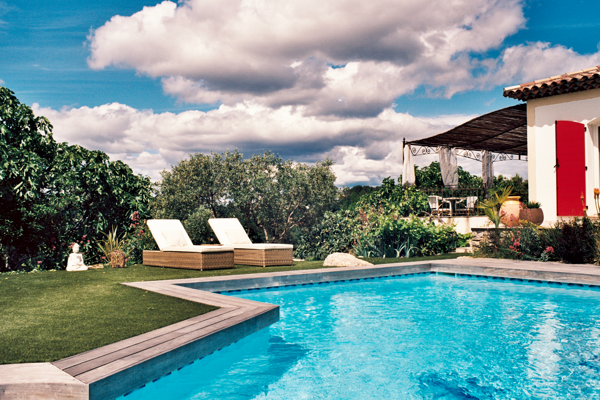 Piscine extérieure avec deux bains de soleil confortables