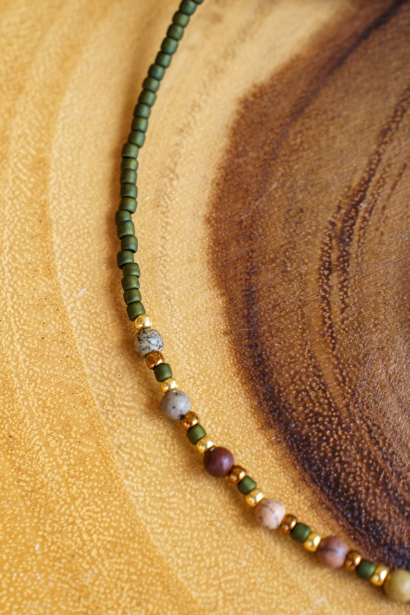 Handmade pink zebra jasper necklace with green and gold seed beads and 18k gold PVD findings. Necklace measures approximately 16" with a 2" extender.