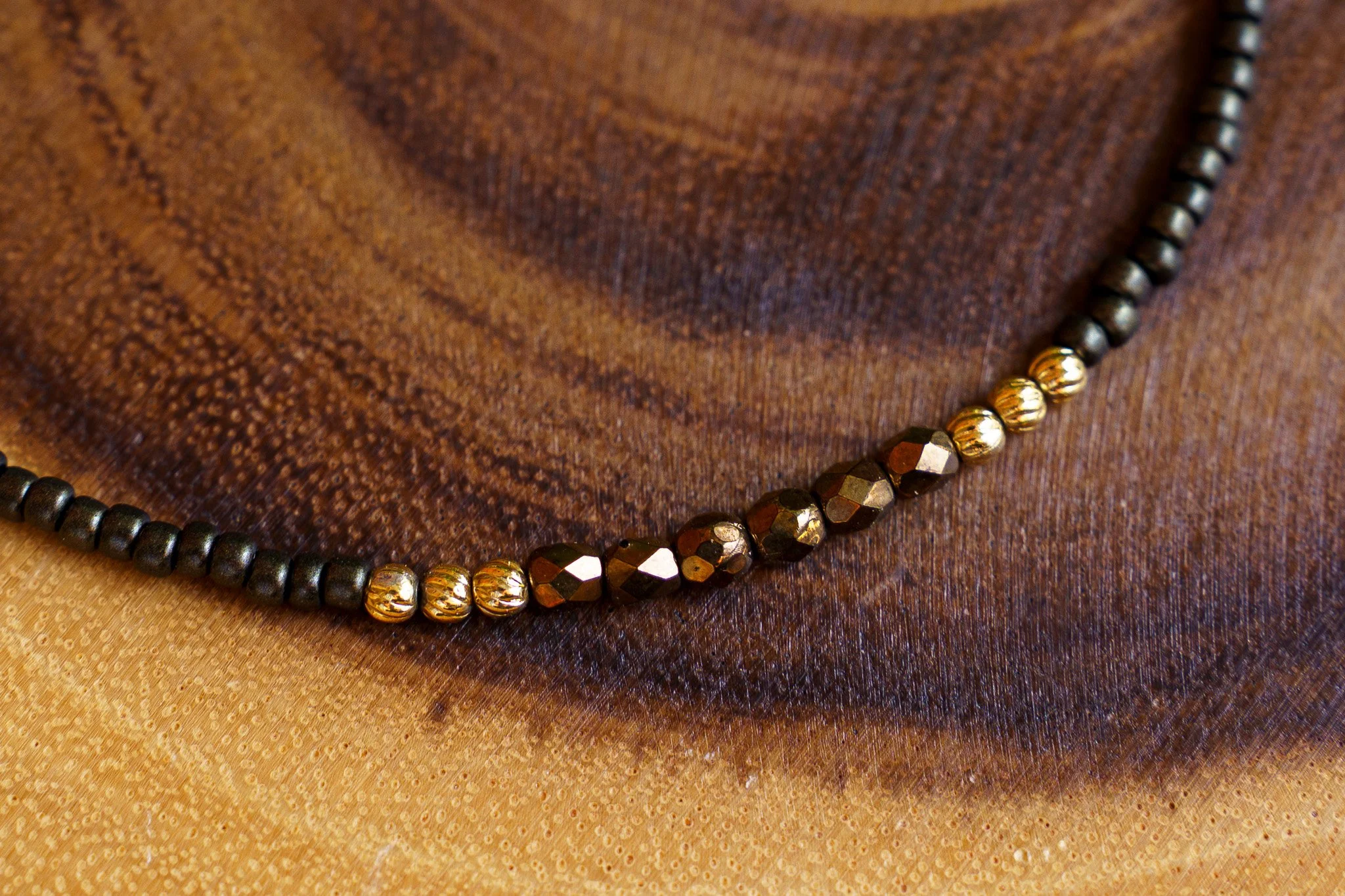 Handmade necklace with brown accent beads with black and gold seed beads and 18k gold PVD findings. Necklace measures approximately 15.5" with a 2" extender.