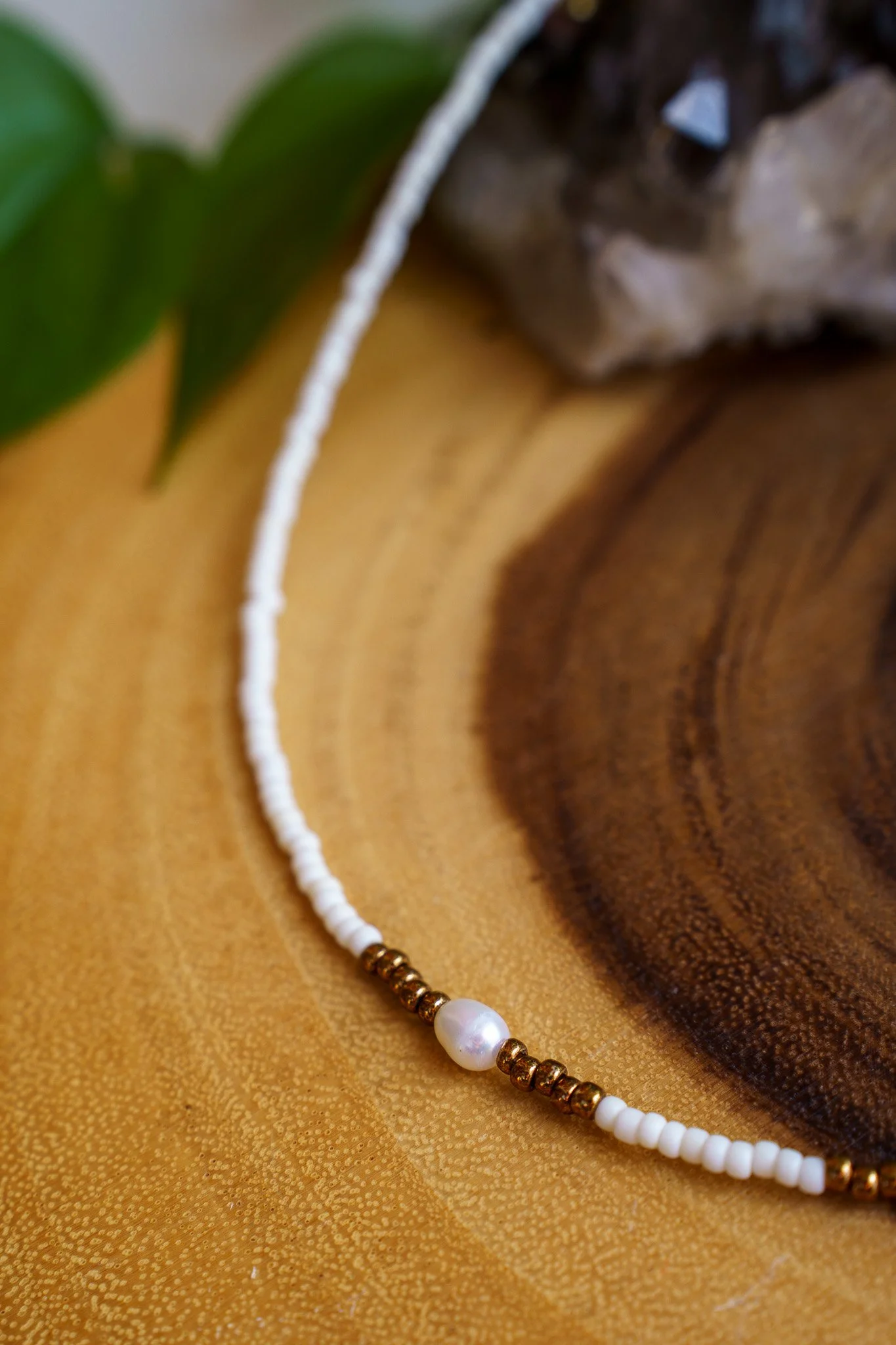 Handmade necklace with three white pearls and white and bronze seed beads with 18k gold PVD findings. Necklace measures approximately 16" with a 2" extender.