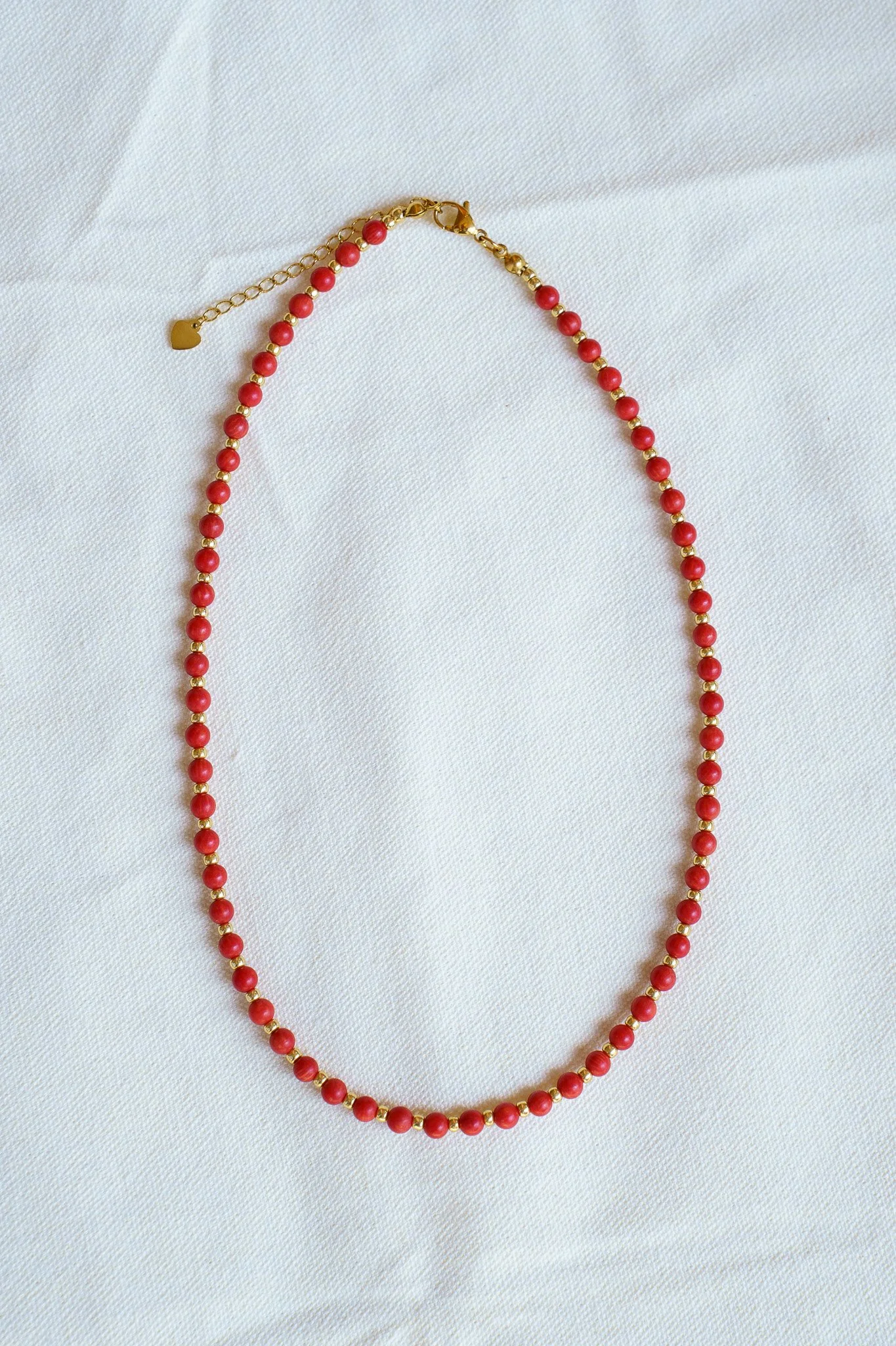 Handmade coral bead necklace with gold seed beads and 18k gold PVD findings. Necklace measures approximately 17" with a 2" extender.