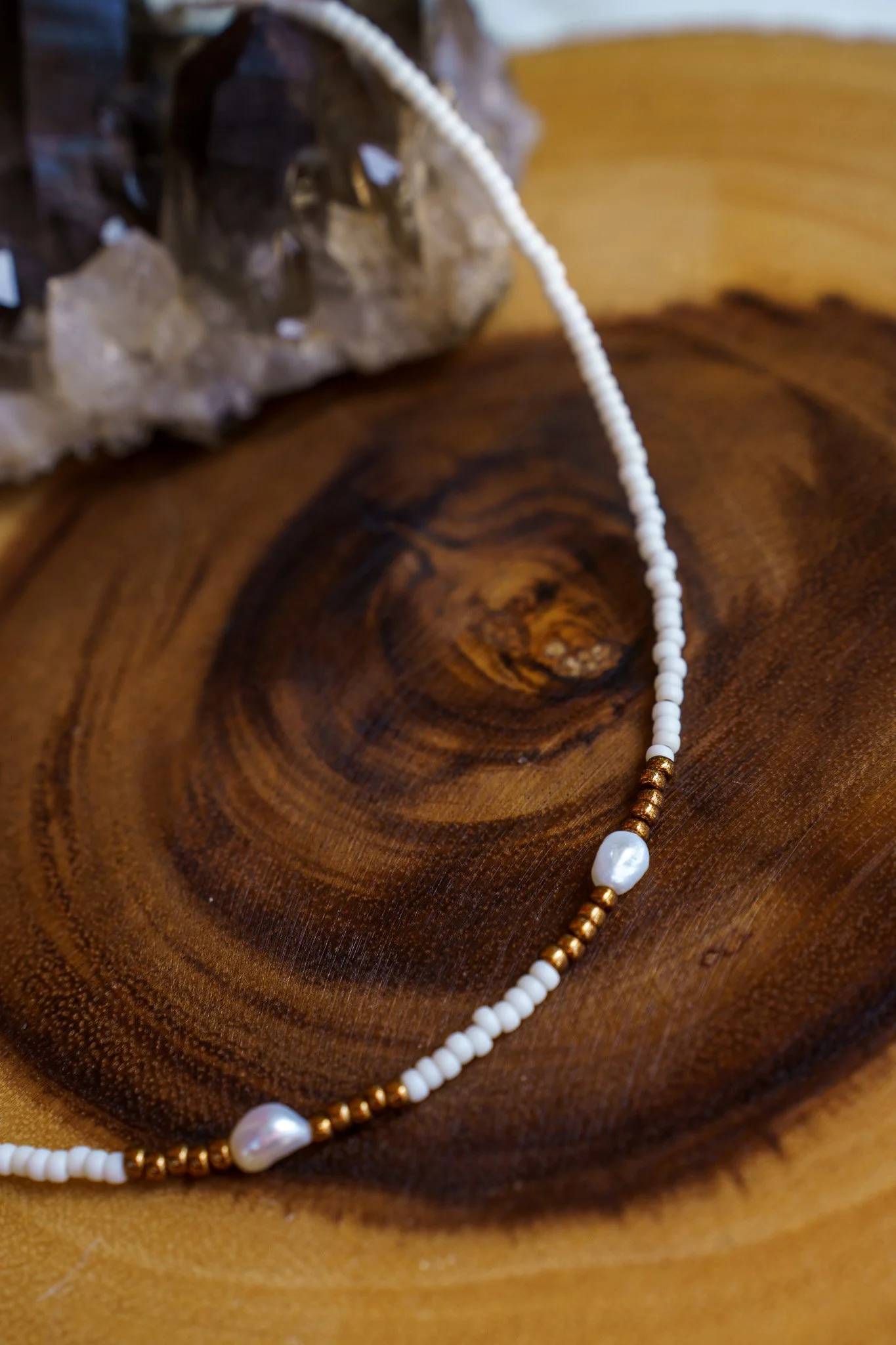 Handmade necklace with three white pearls and white and bronze seed beads with 18k gold PVD findings. Necklace measures approximately 16" with a 2" extender.