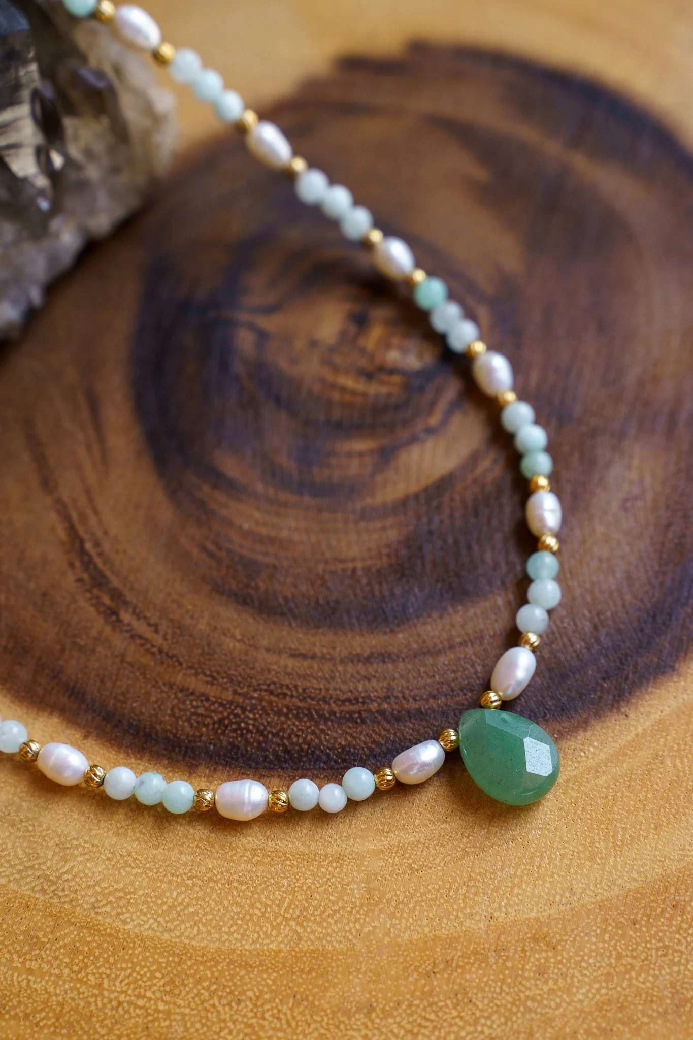 Handmade necklace with amazonite beads, freshwater pearls, and a green aventurine pendant with gold seed beads and 18k gold PVD findings. Necklace measures approximately 15" with a 2" extender.