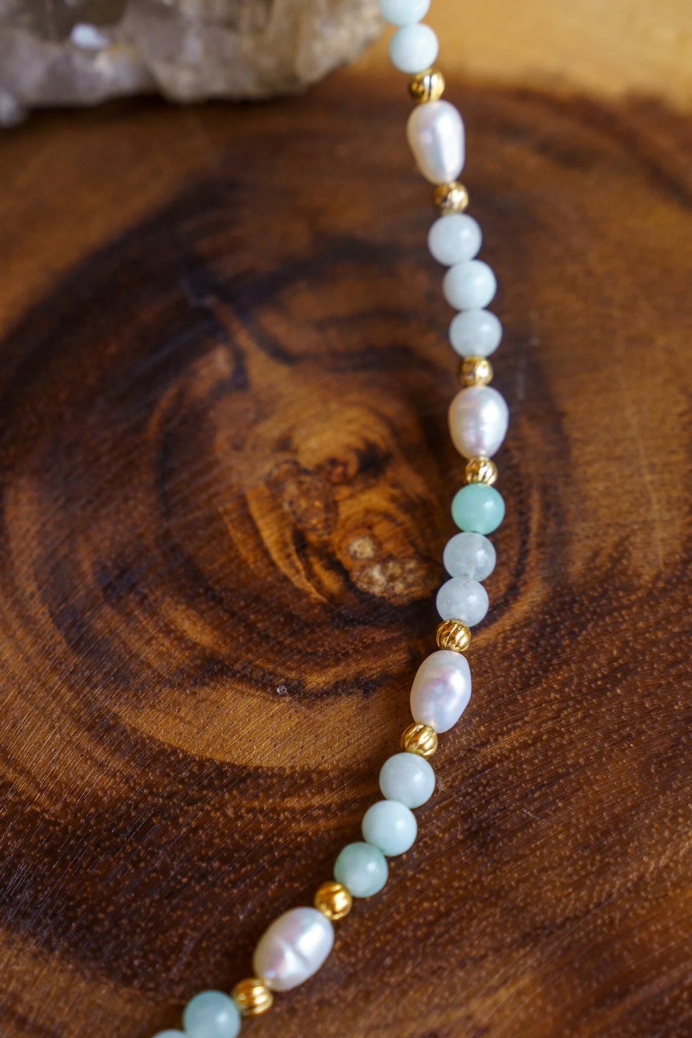 Handmade necklace with amazonite beads, freshwater pearls, and a green aventurine pendant with gold seed beads and 18k gold PVD findings. Necklace measures approximately 15" with a 2" extender.
