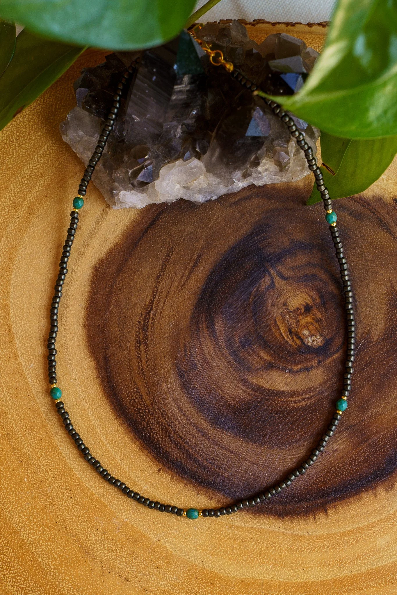 Handmade necklace with teal accent beads and black and gold seed beads with 18k gold PVD findings. Necklace measures approximately 17" with a 2" extender.