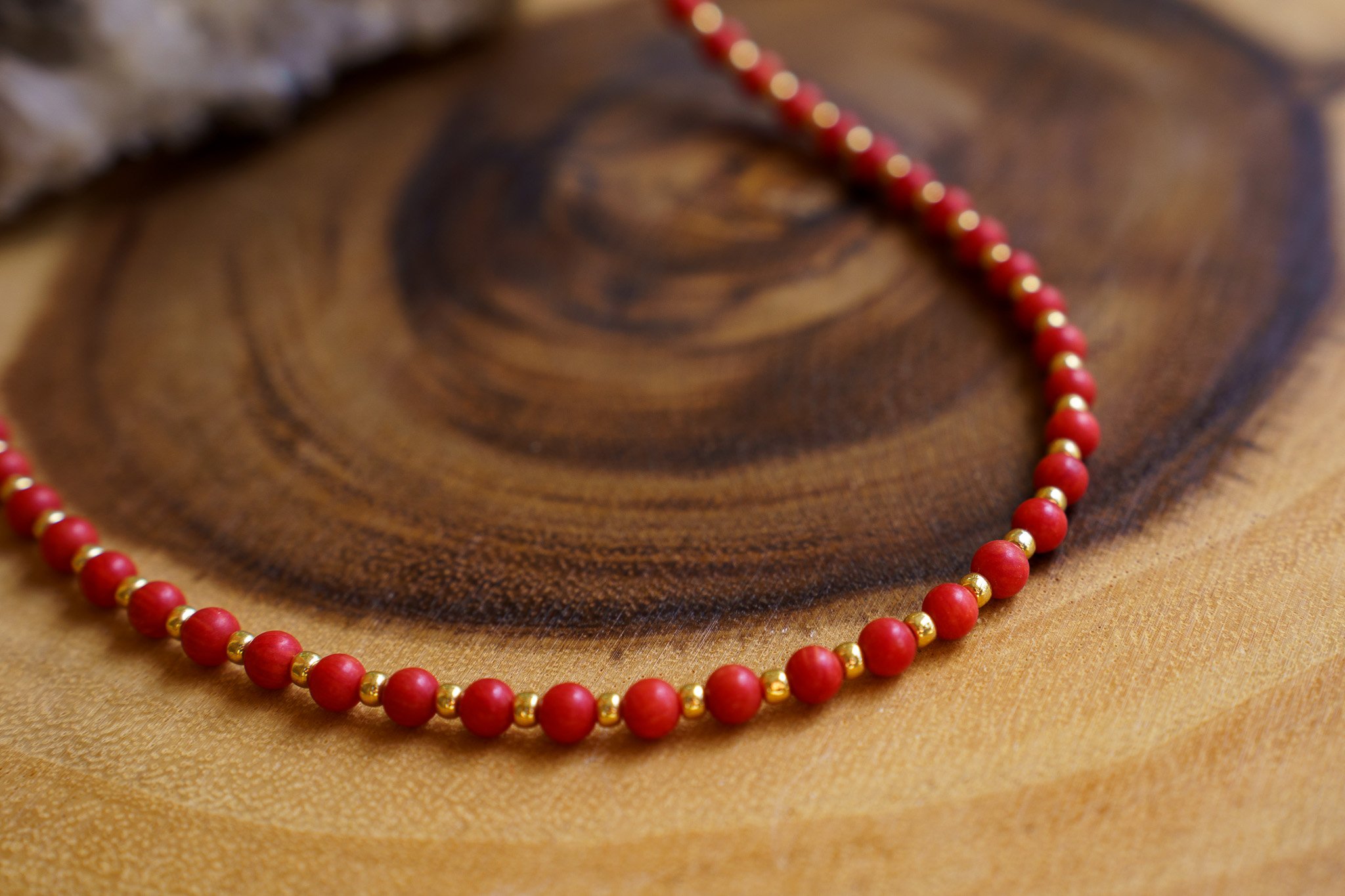 Handmade coral bead necklace with gold seed beads and 18k gold PVD findings. Necklace measures approximately 17" with a 2" extender.