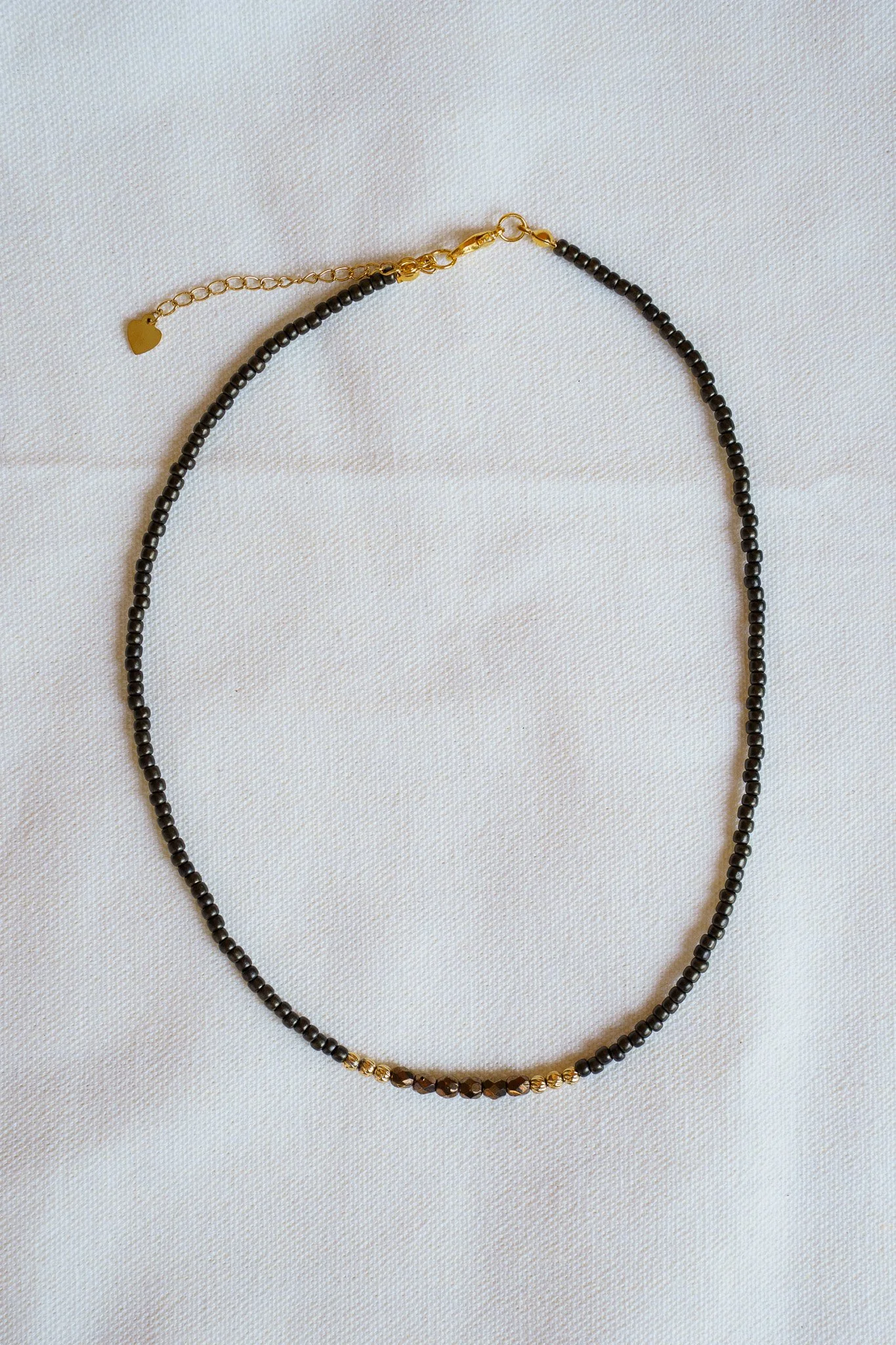Handmade necklace with brown accent beads with black and gold seed beads and 18k gold PVD findings. Necklace measures approximately 15.5" with a 2" extender.