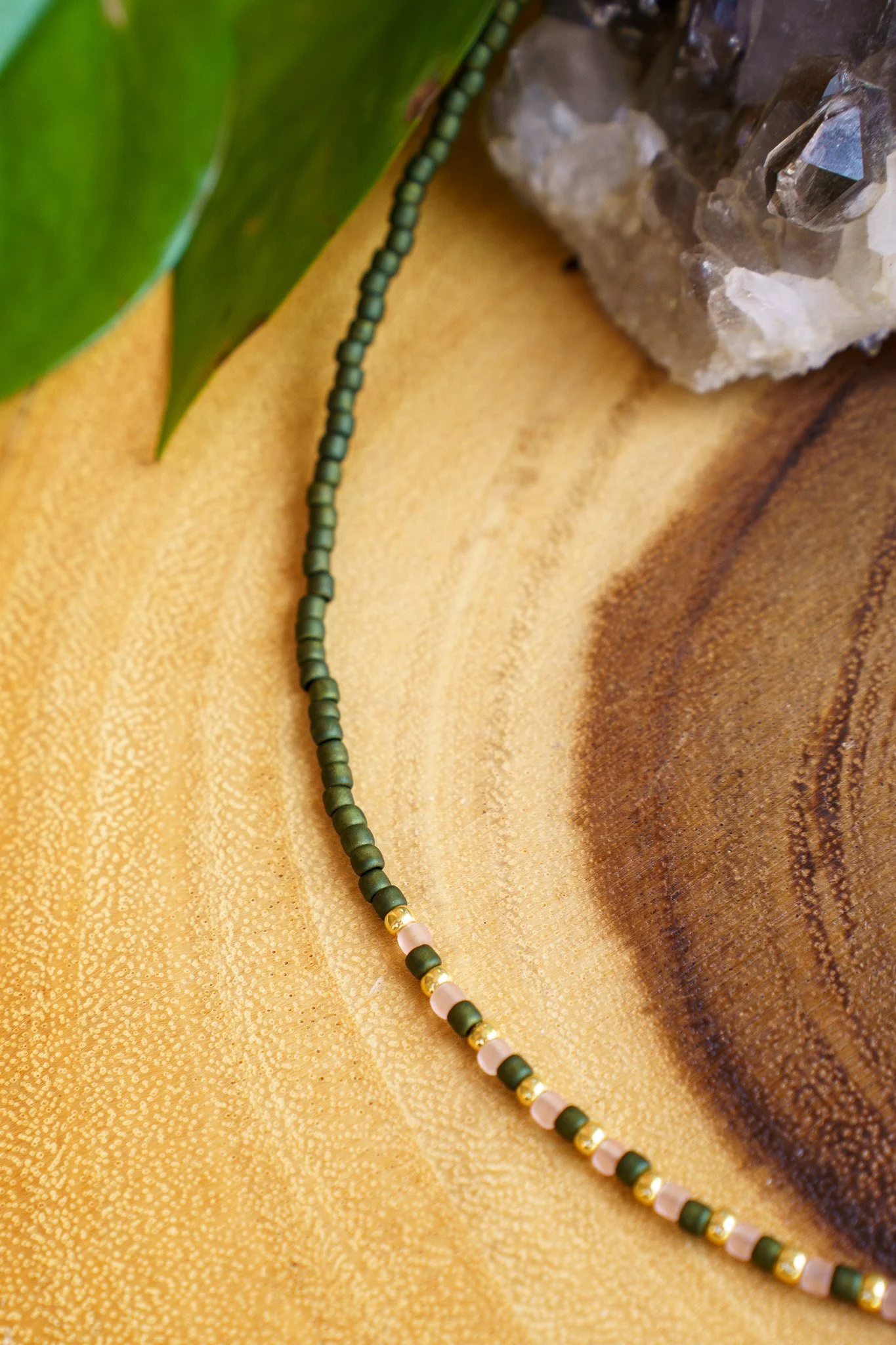 Handmade green, pink, and gold seed bead necklace with 18k gold PVD findings. Necklace measures approximately 16" with a 2" extender.