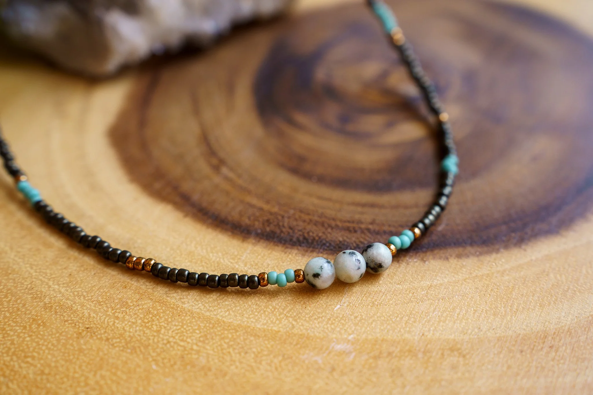 Handmade necklace with three kiwi jasper stones and black and bronze seed beads with 18k gold PVD findings. Necklace measures approximately 16" with a 2" extender.