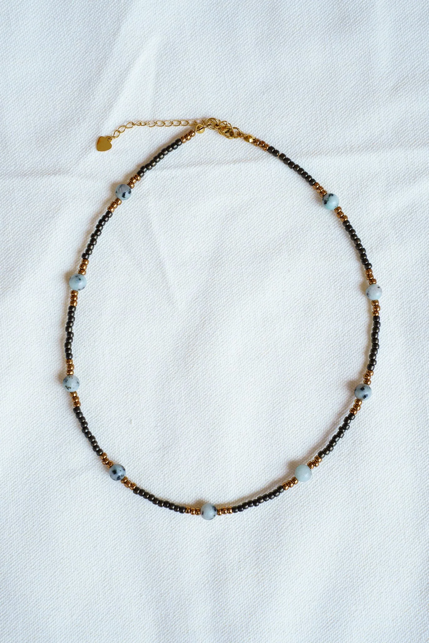 Handmade kiwi jasper necklace with black and bronze seed beads and 18k gold PVD findings. Necklace measures approximately 16" with a 2" extender.