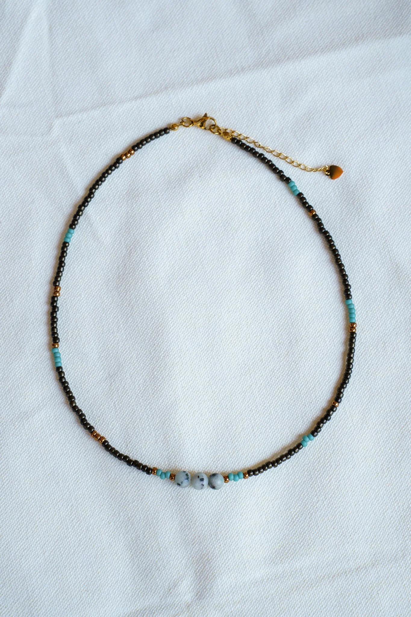 Handmade necklace with three kiwi jasper stones and black and bronze seed beads with 18k gold PVD findings. Necklace measures approximately 16" with a 2" extender.