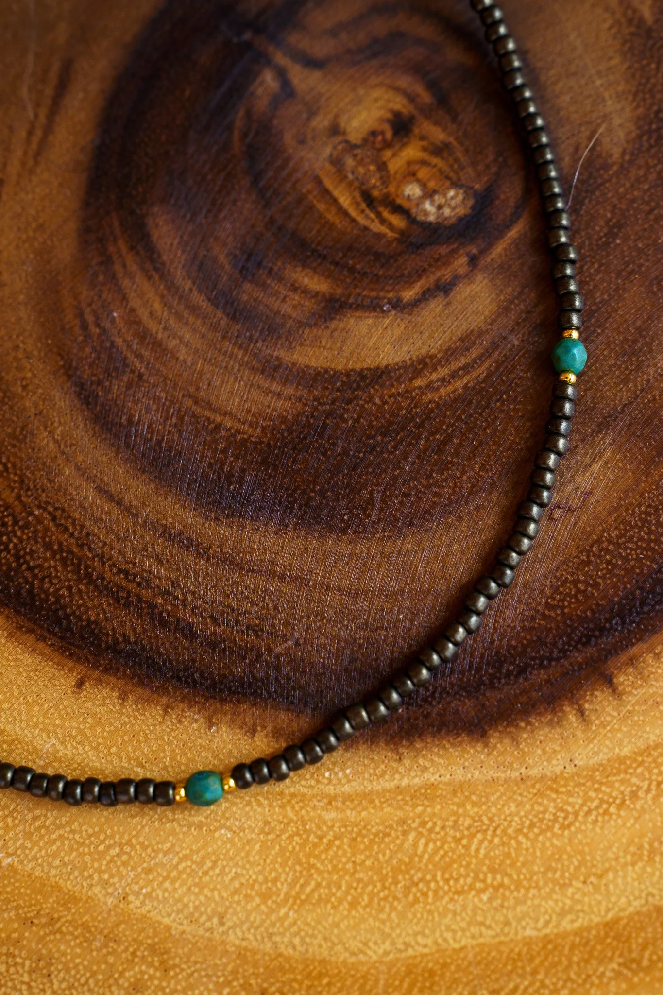 Handmade necklace with teal accent beads and black and gold seed beads with 18k gold PVD findings. Necklace measures approximately 17" with a 2" extender.